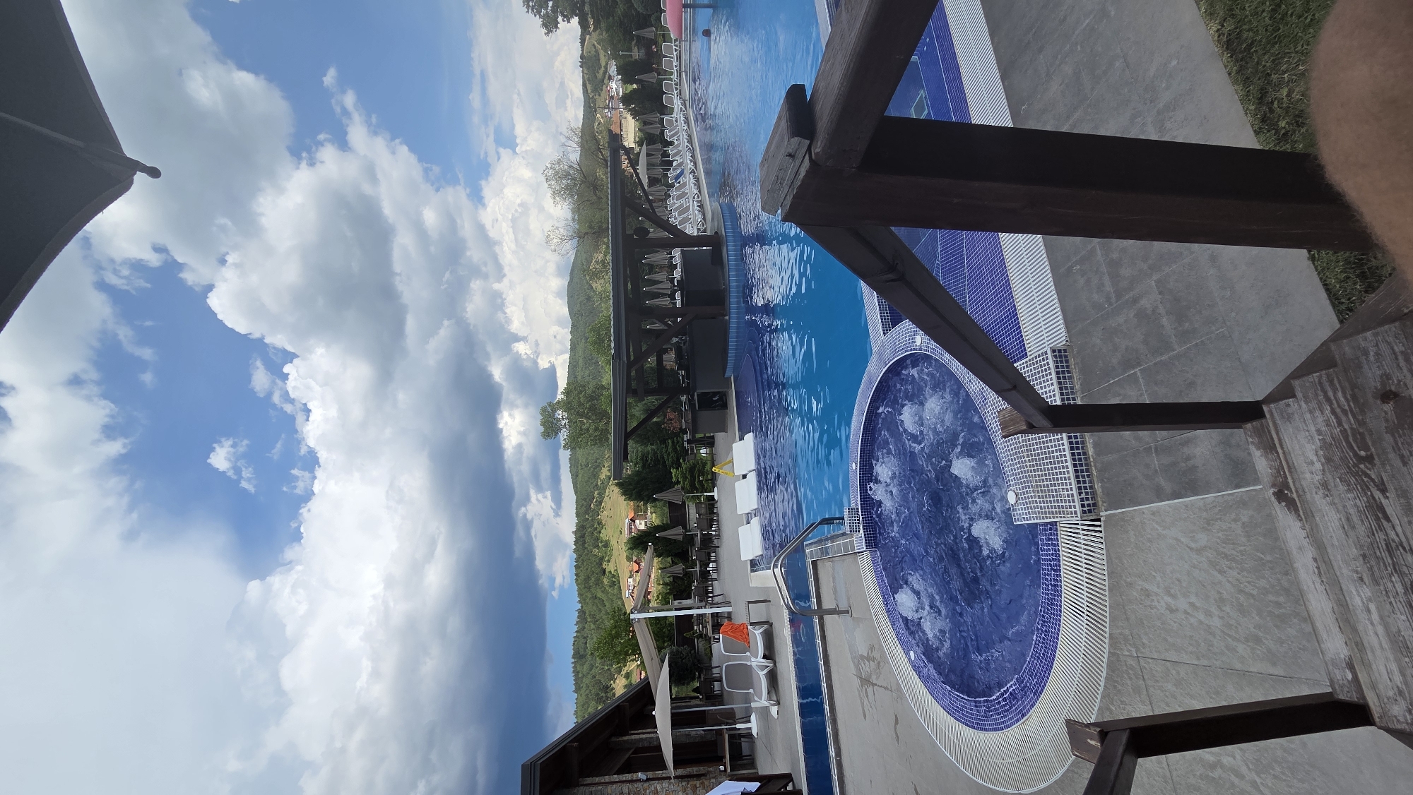 Pool and jacuzzi facility documented under cloudy afternoon skies