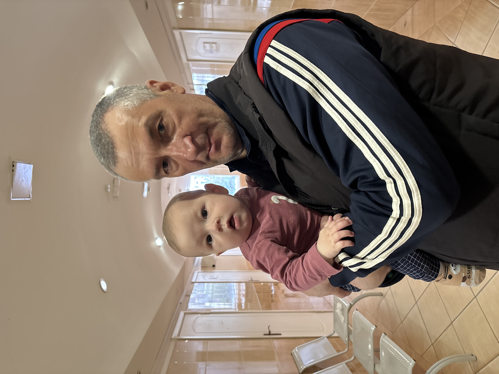 Man holds baby in Sochi medical facility waiting area