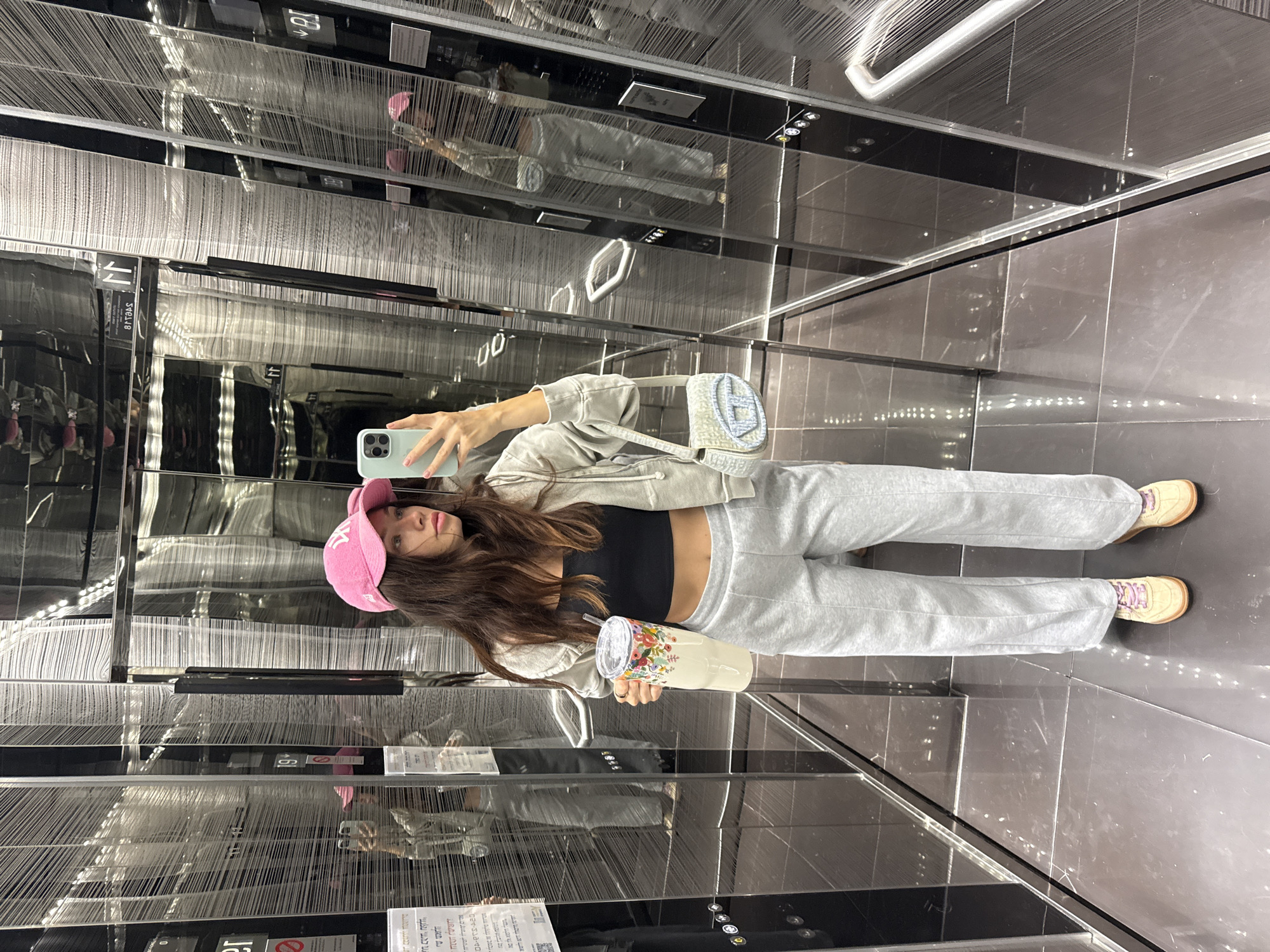 Woman takes selfie in reflective elevator in Ramat Gan