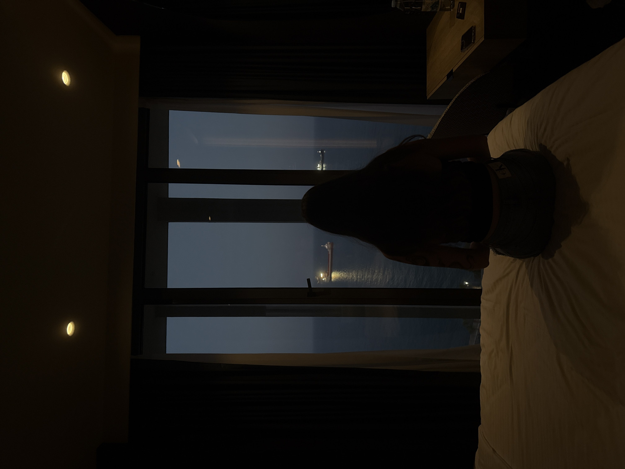 Dimly lit Limassol hotel room with Mediterranean sea view at dusk