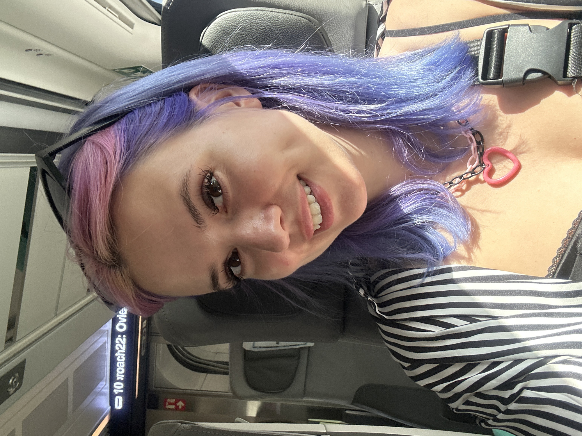 Woman with colorful hair photographed smiling on Spanish train