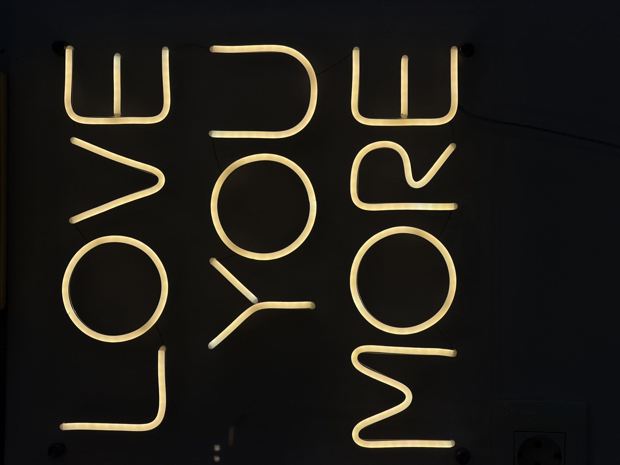 Neon signs including "LOVE YOU MORE" message documented