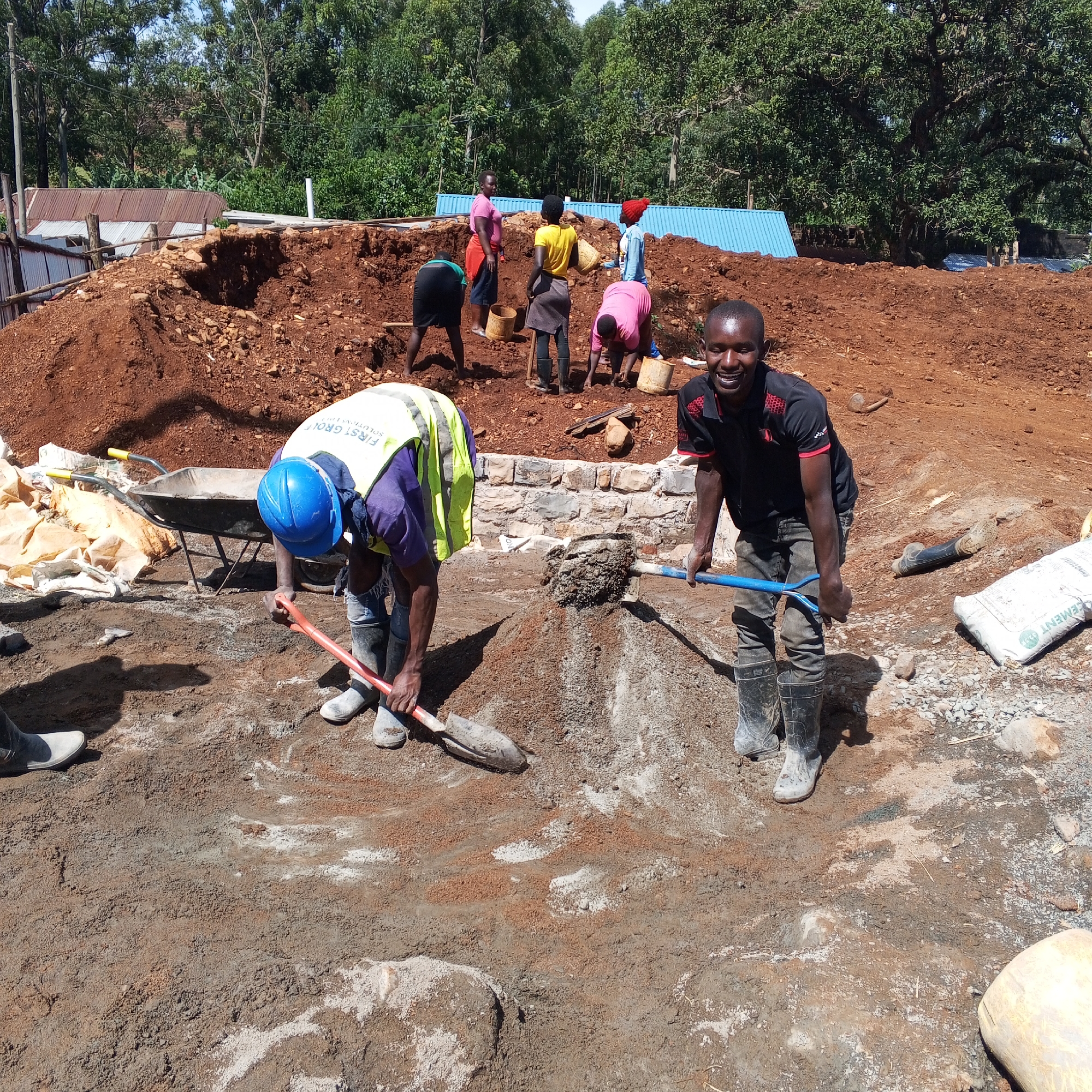 Construction crew performs manual labor at outdoor earthworks site