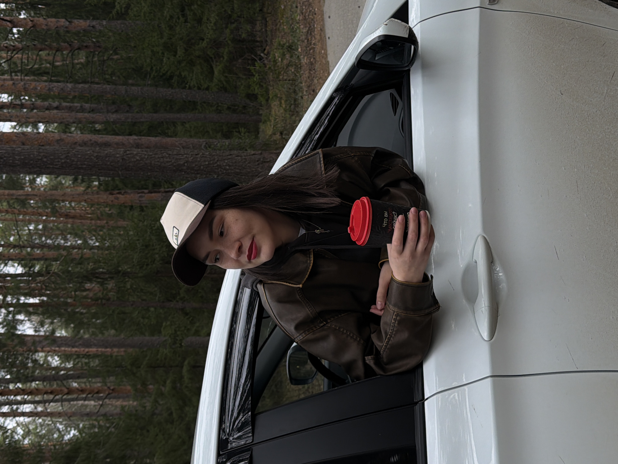 Woman photographed leaning from car window near Russian forest