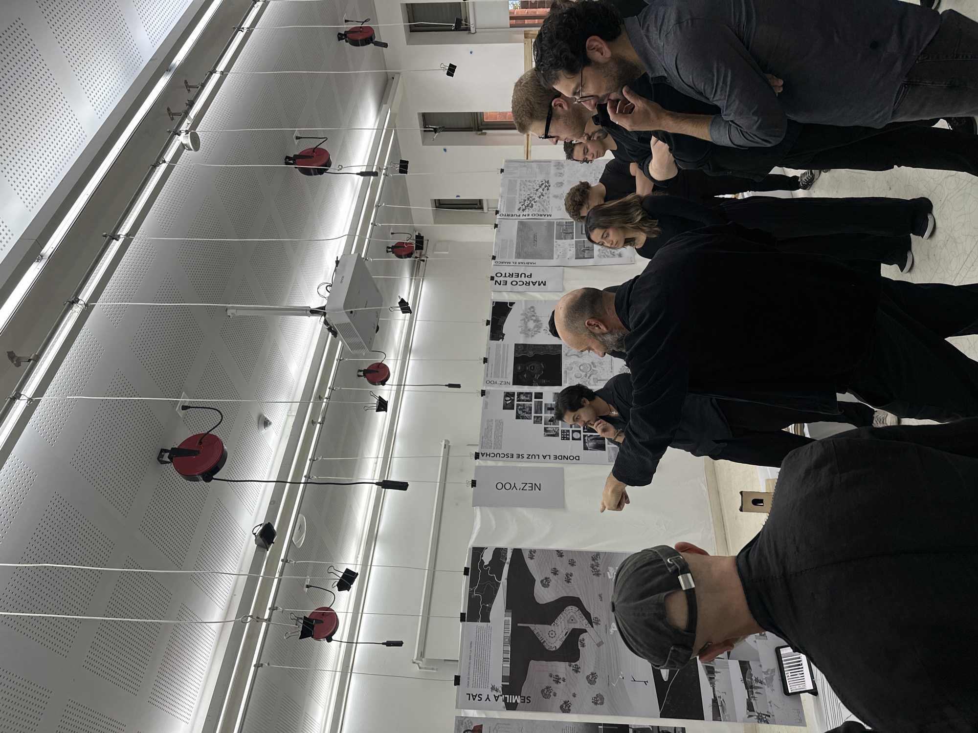 Design students examine architectural posters at Mexico City university exhibition