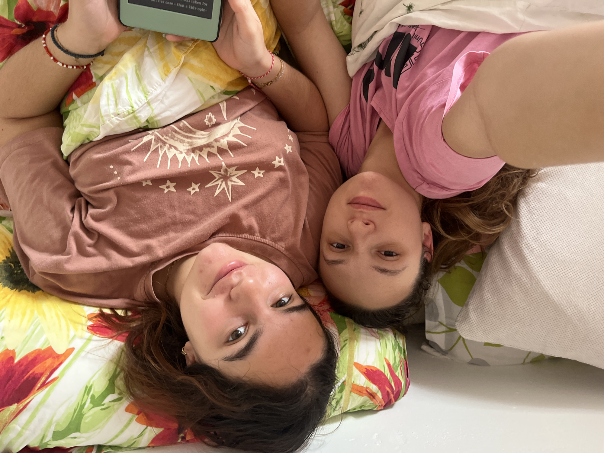 Two women relax on bed with phone in Saarbrücken
