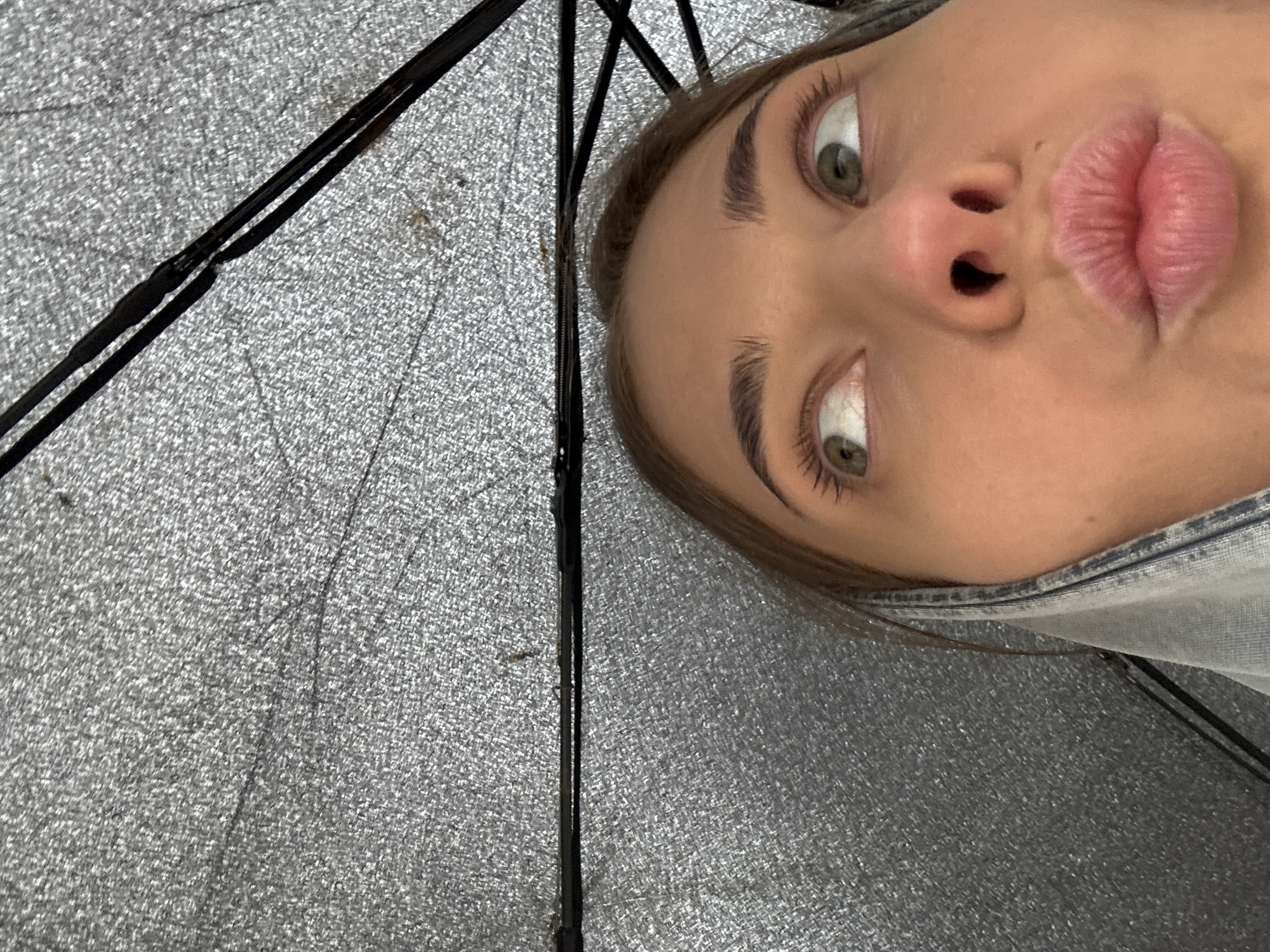 Woman shelters under umbrella during rainfall in Chernushka, Russia