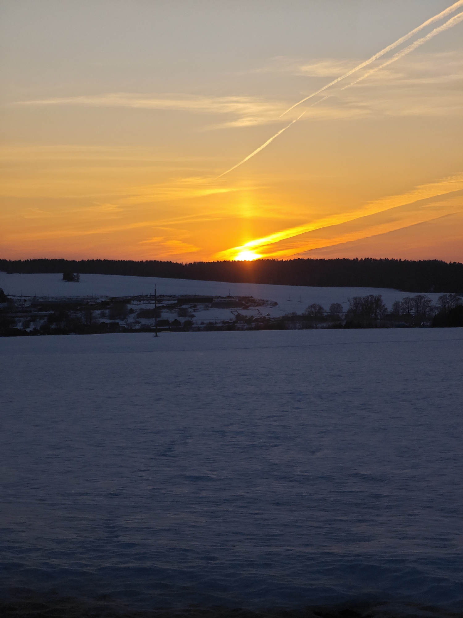 Sunset illuminates snow-covered field near Большая Уса, Russia