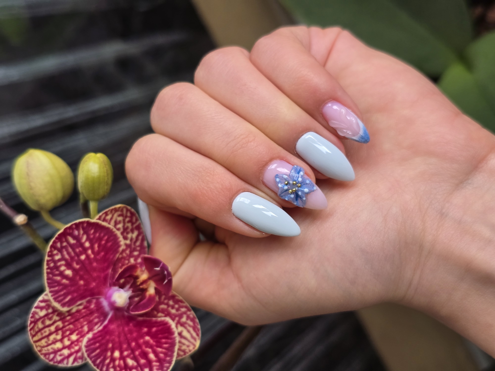 Woman displays decorated nail art with orchid in Burgas