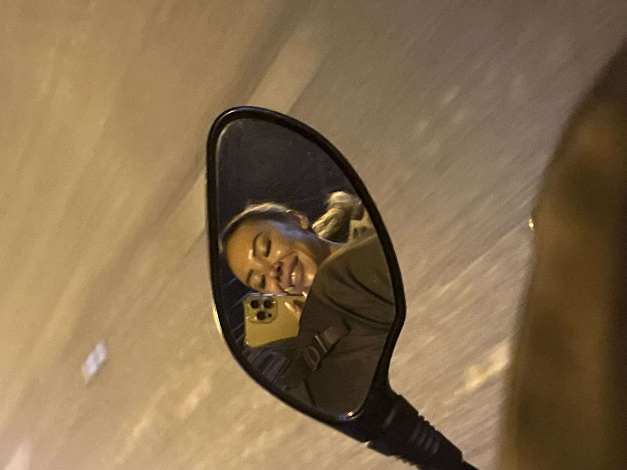 Person with smartphone captured in motorcycle mirror, Rawai Thailand