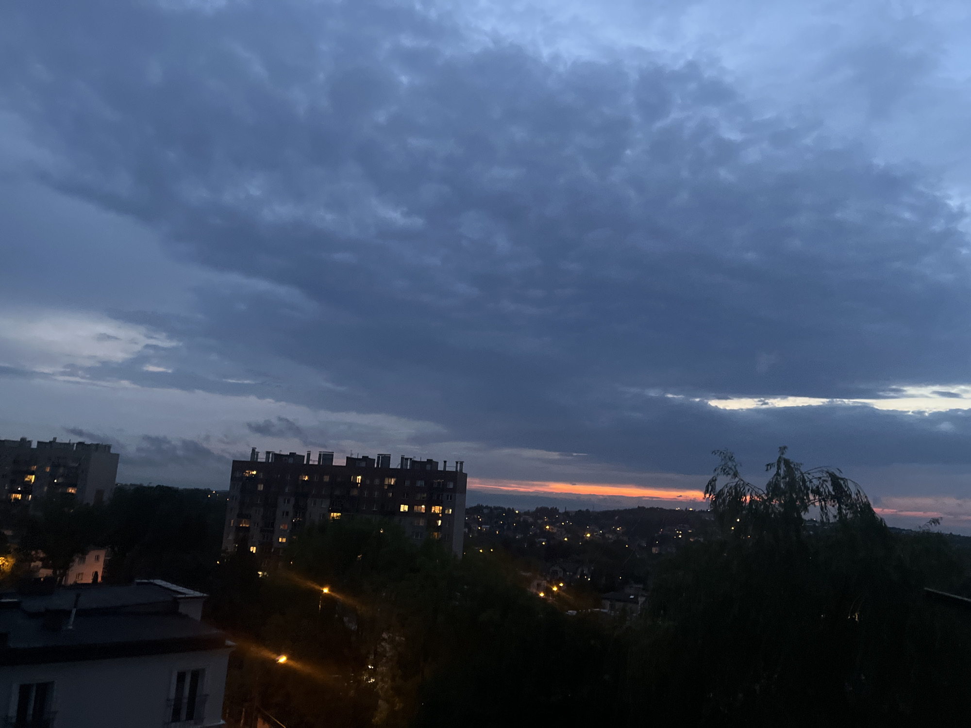 City skyline at dusk, lights coming on across the neighborhood