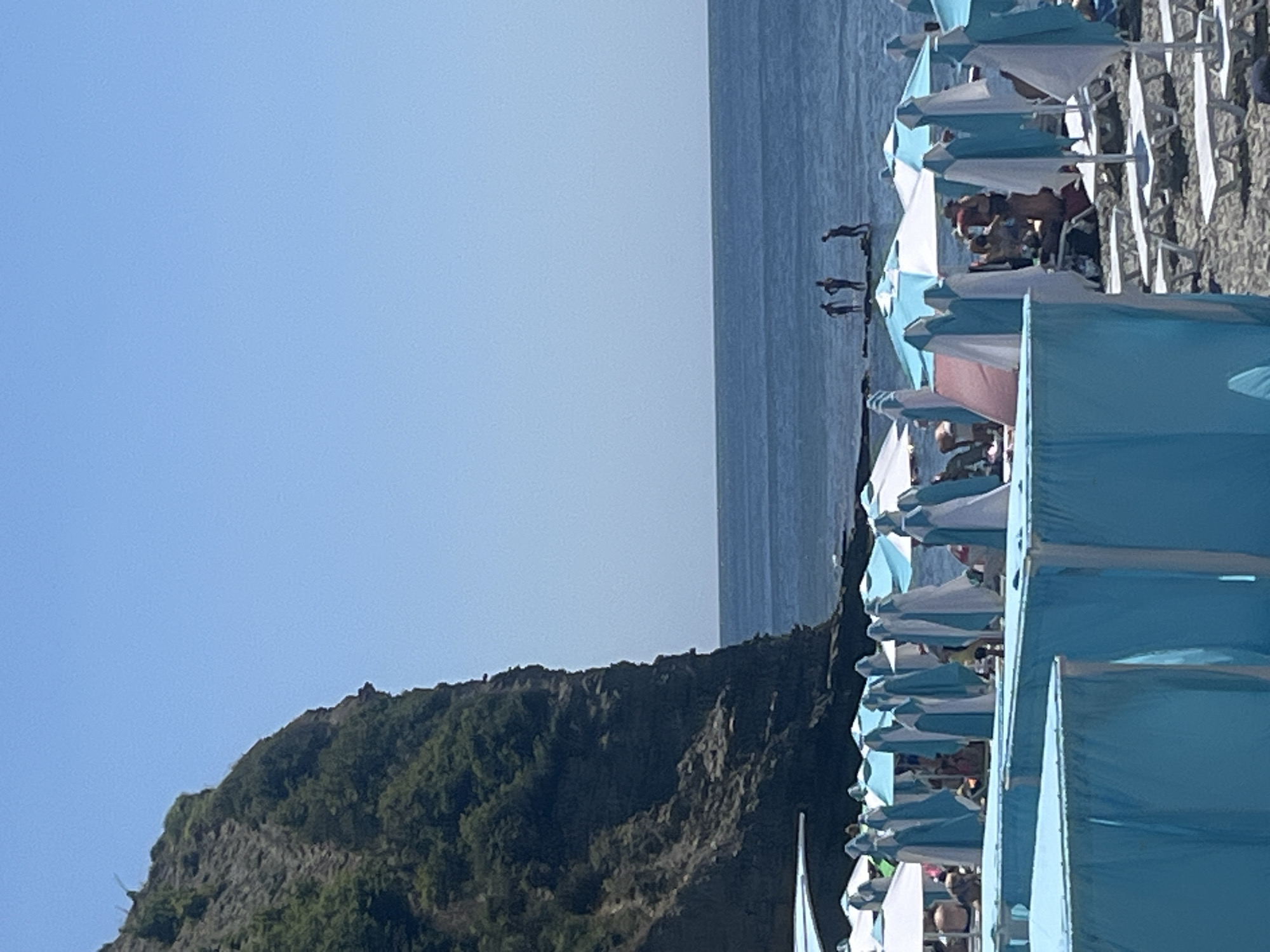Sunny beach day with umbrellas, lounge chairs, and lifeguard post