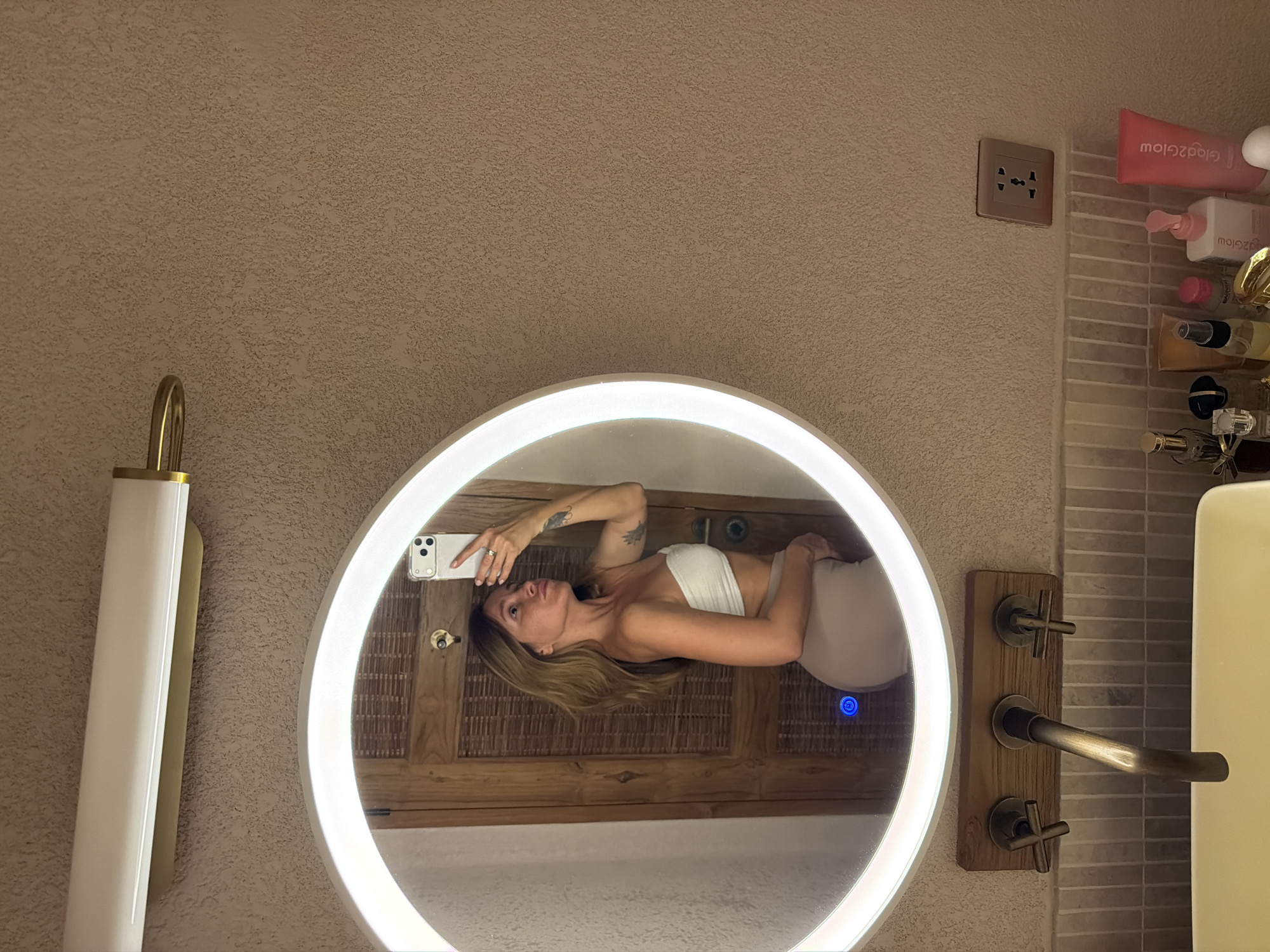 Woman takes mirror selfies in Mengwi bathroom area