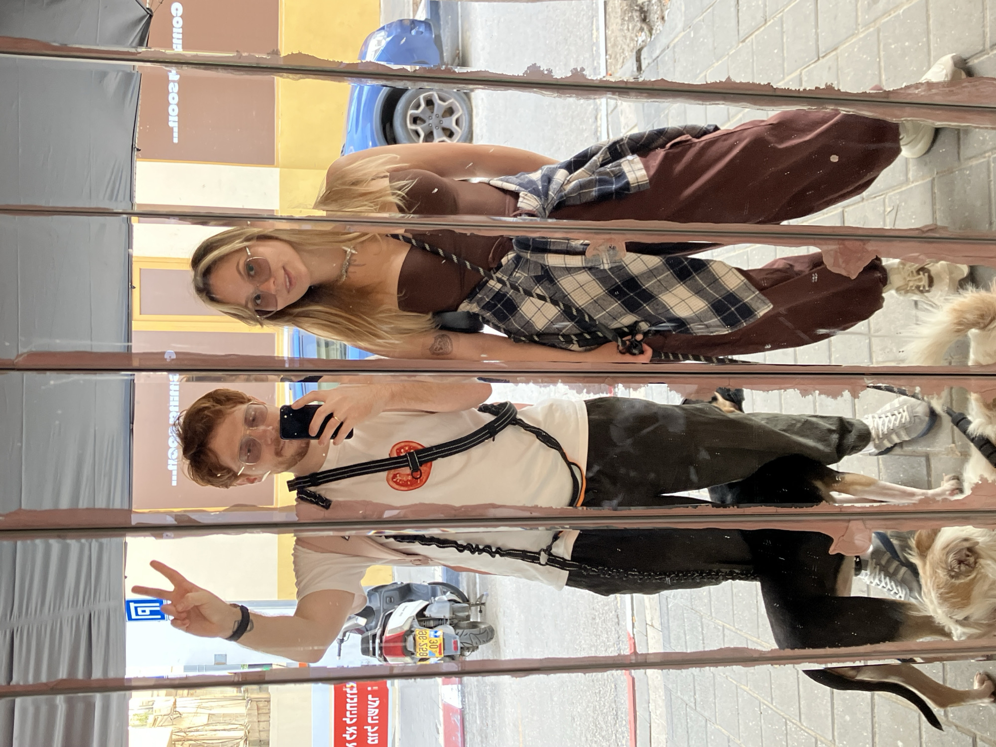 Dog walkers reflected in damaged street mirror in Tel Aviv