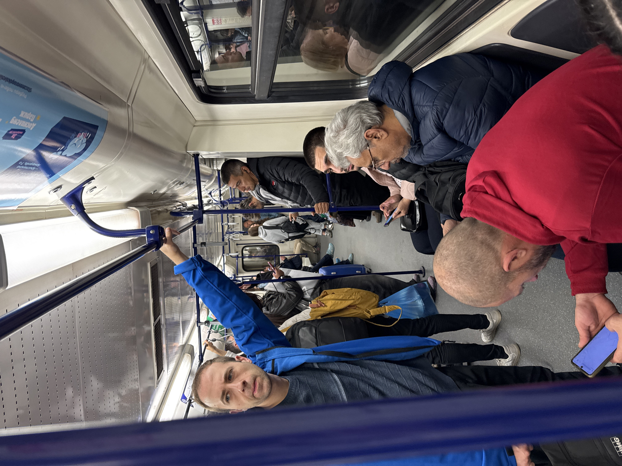 Commuters check phones during subway ride in Sofia
