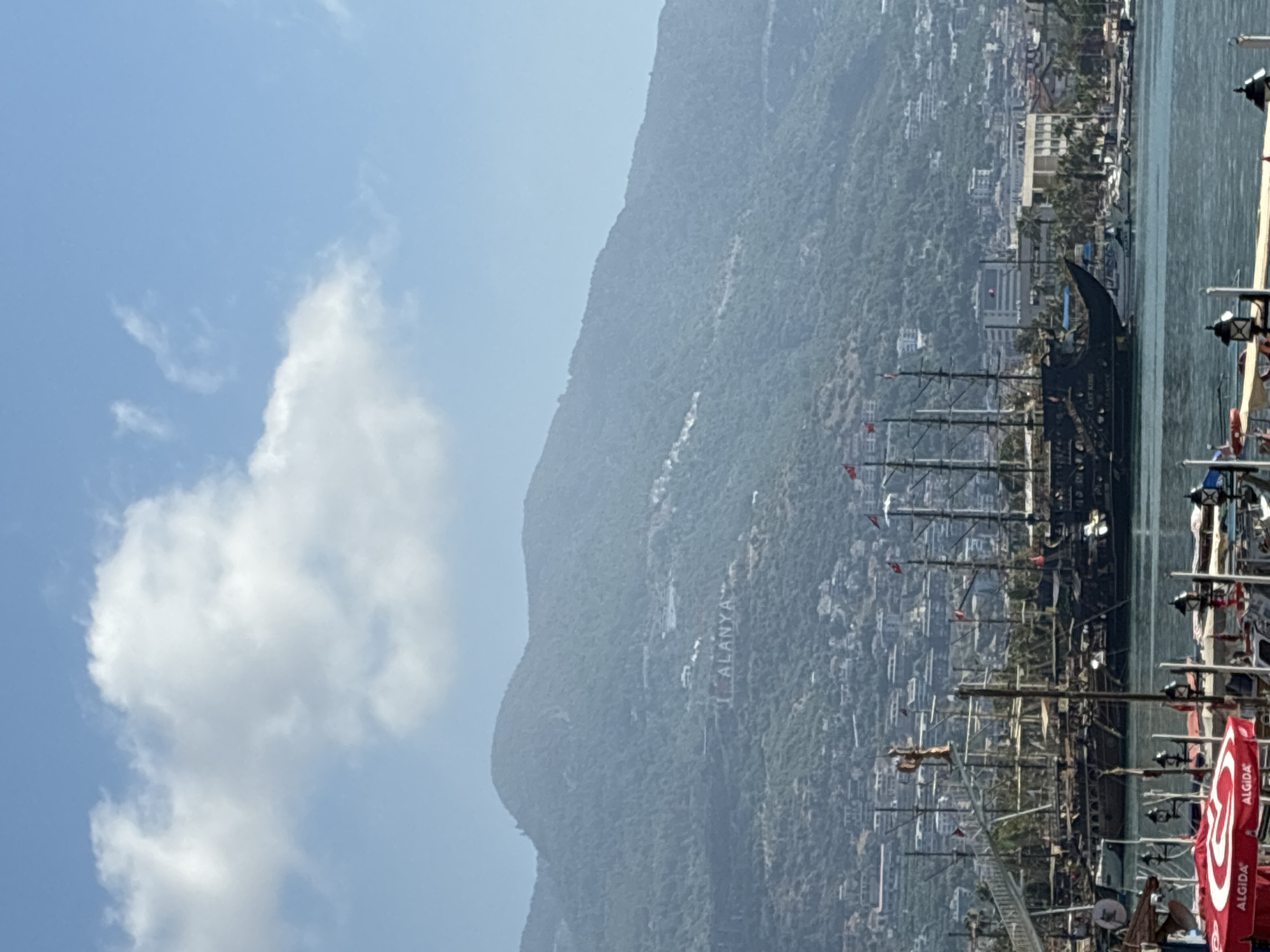 Alanya landmarks: hillside signage and a suited statue