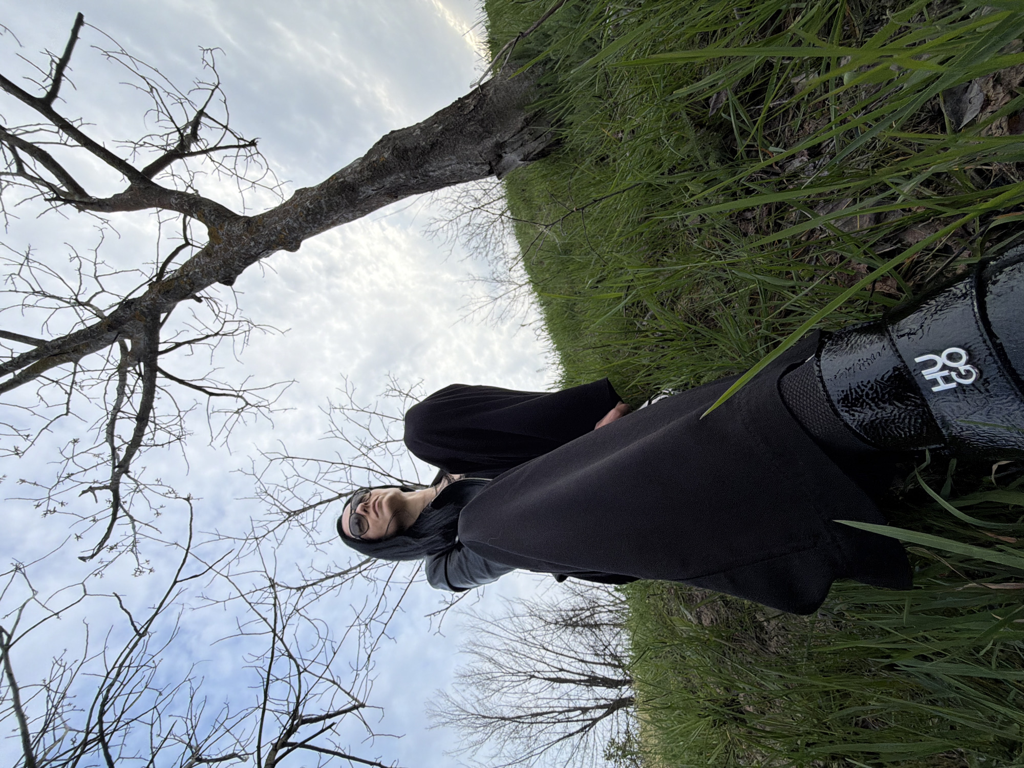 Person in black relaxes in grassy field in Pleven