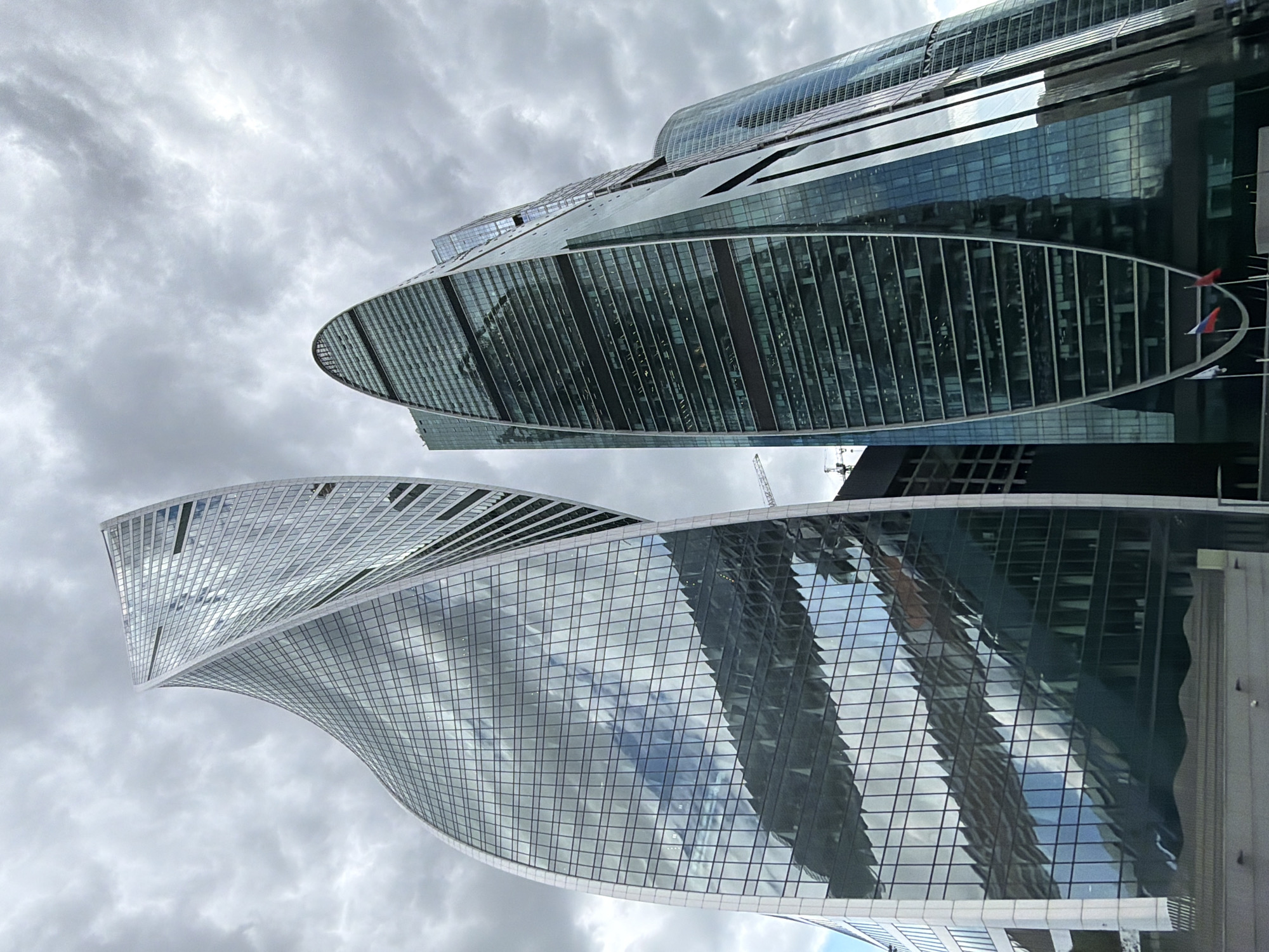 Moscow skyscrapers observed under gray skies, taxi spotted nearby