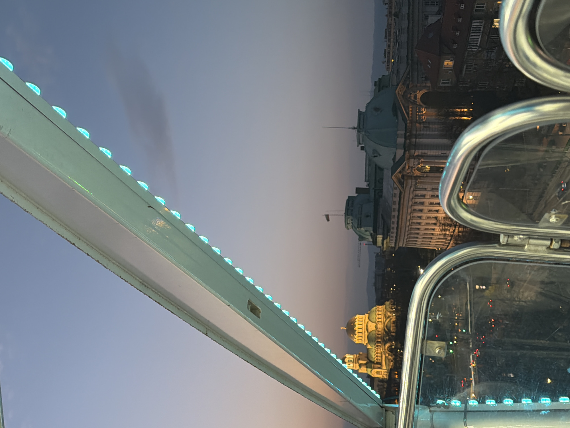 Ferris wheel rider captures Sofia cityscape at dusk