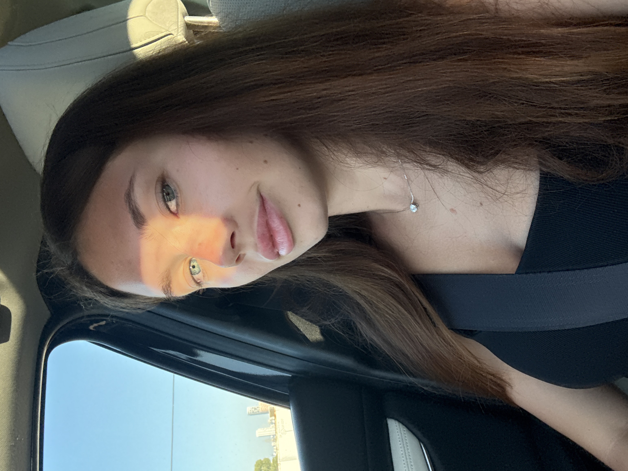 Woman photographed in car with Tel Aviv cityscape visible