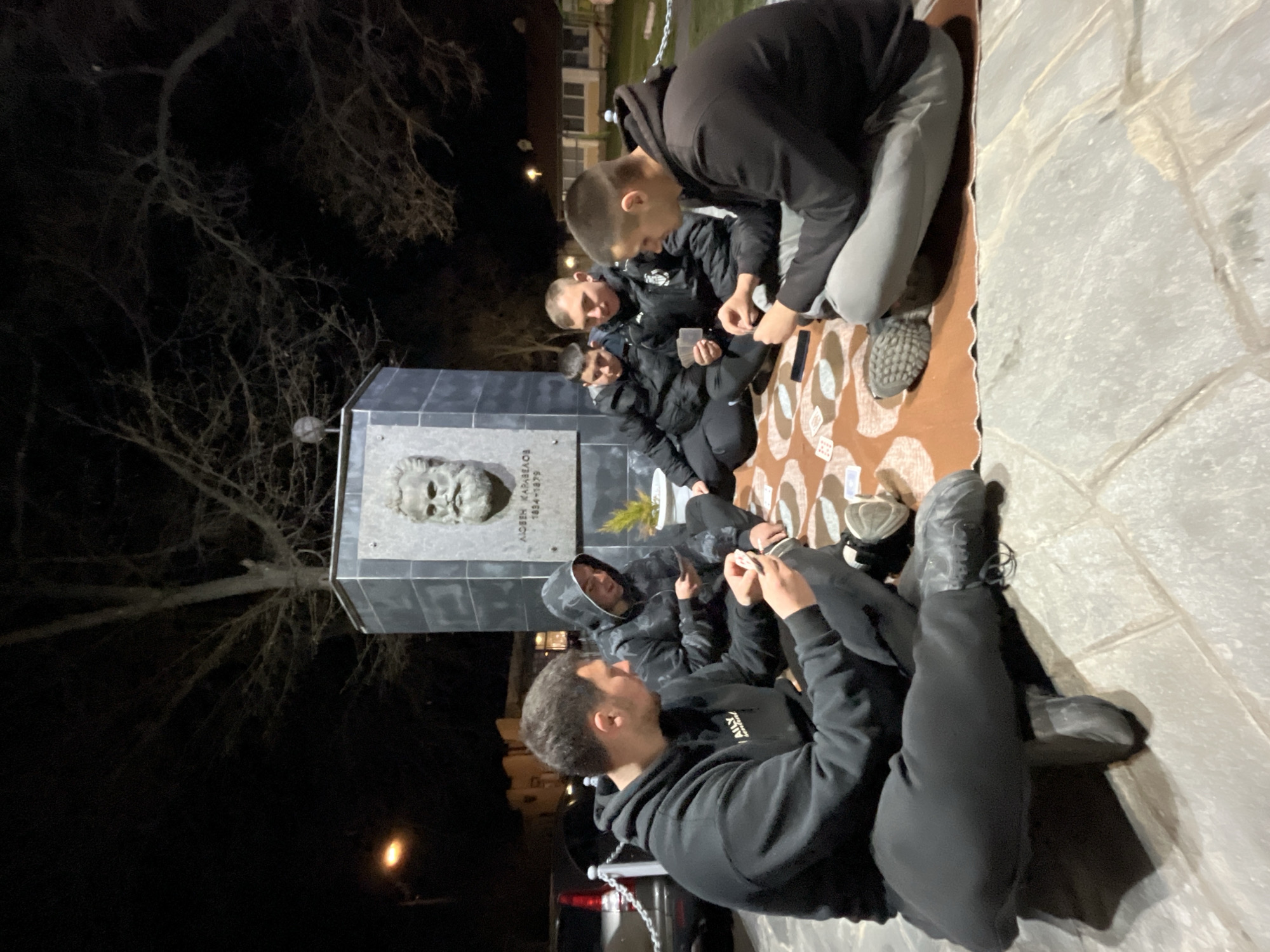 Evening card game gathering near monument in Karavelovo, Bulgaria