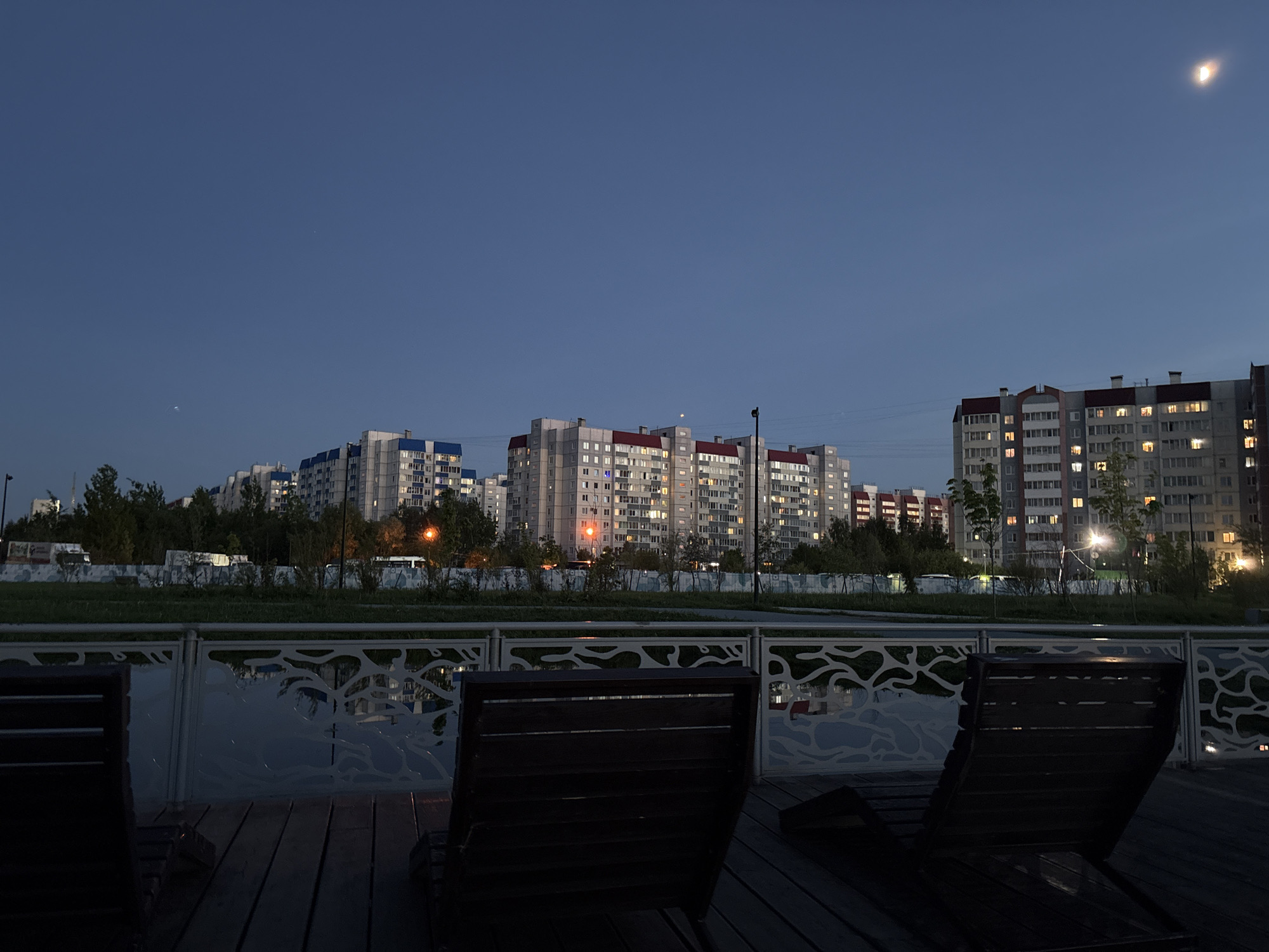 Urban apartment buildings illuminated at dusk captured by witness