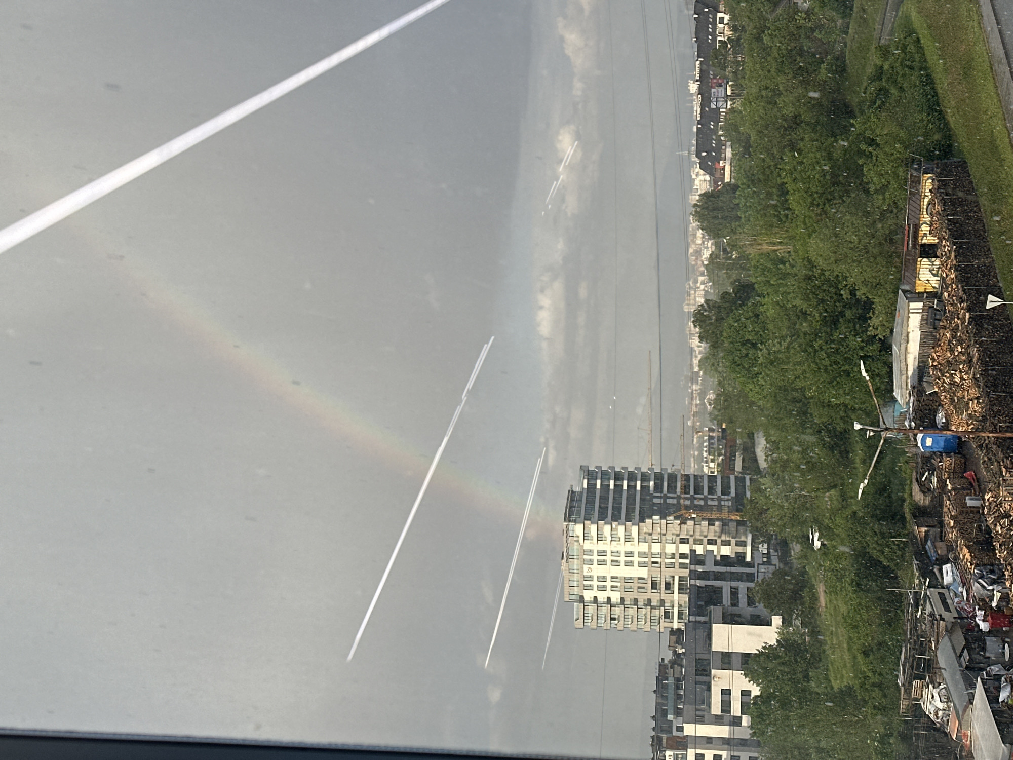 Rainbow appears over Sofia cityscape during afternoon hours