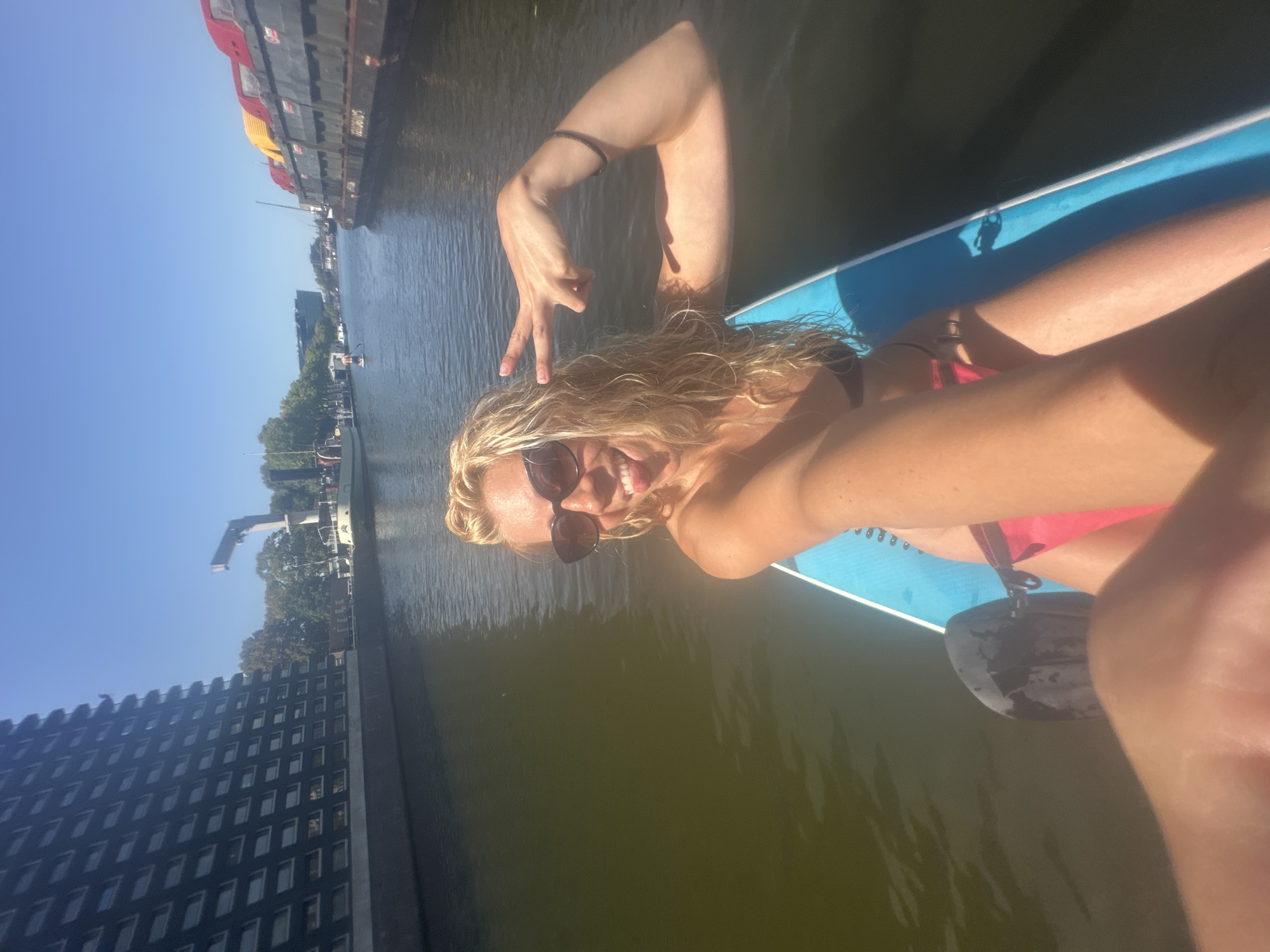 Stand-up paddleboarding through Amsterdam's canals on a summer morning.