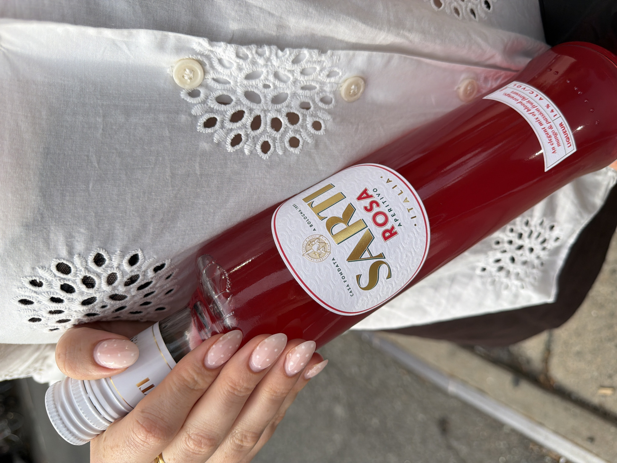 Sarti Rosa Aperitivo bottle held for a closer look