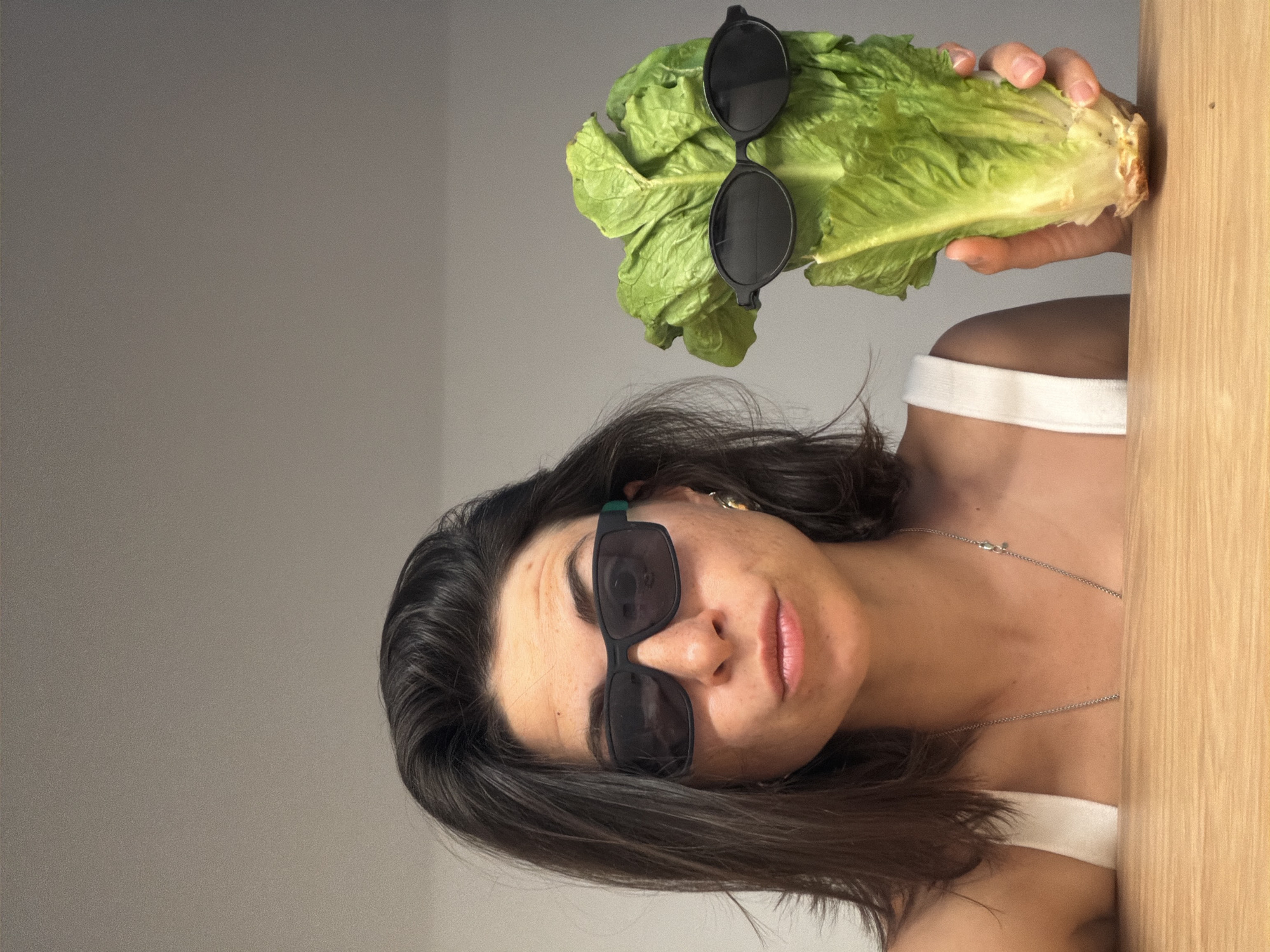 Woman poses with sunglasses-wearing lettuce in playful Montenegro photo session