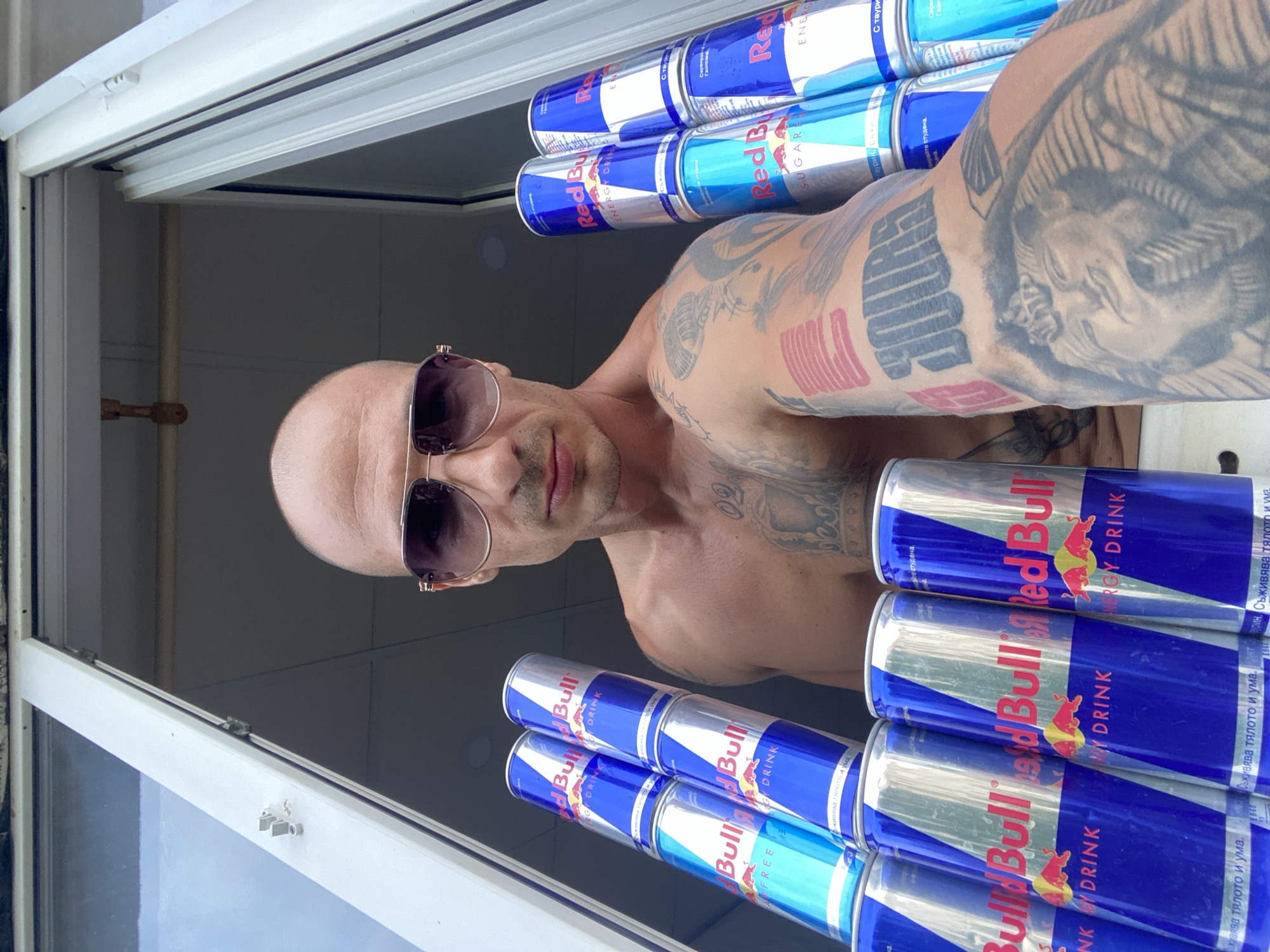 Tattooed man holds Red Bull cans in Pleven