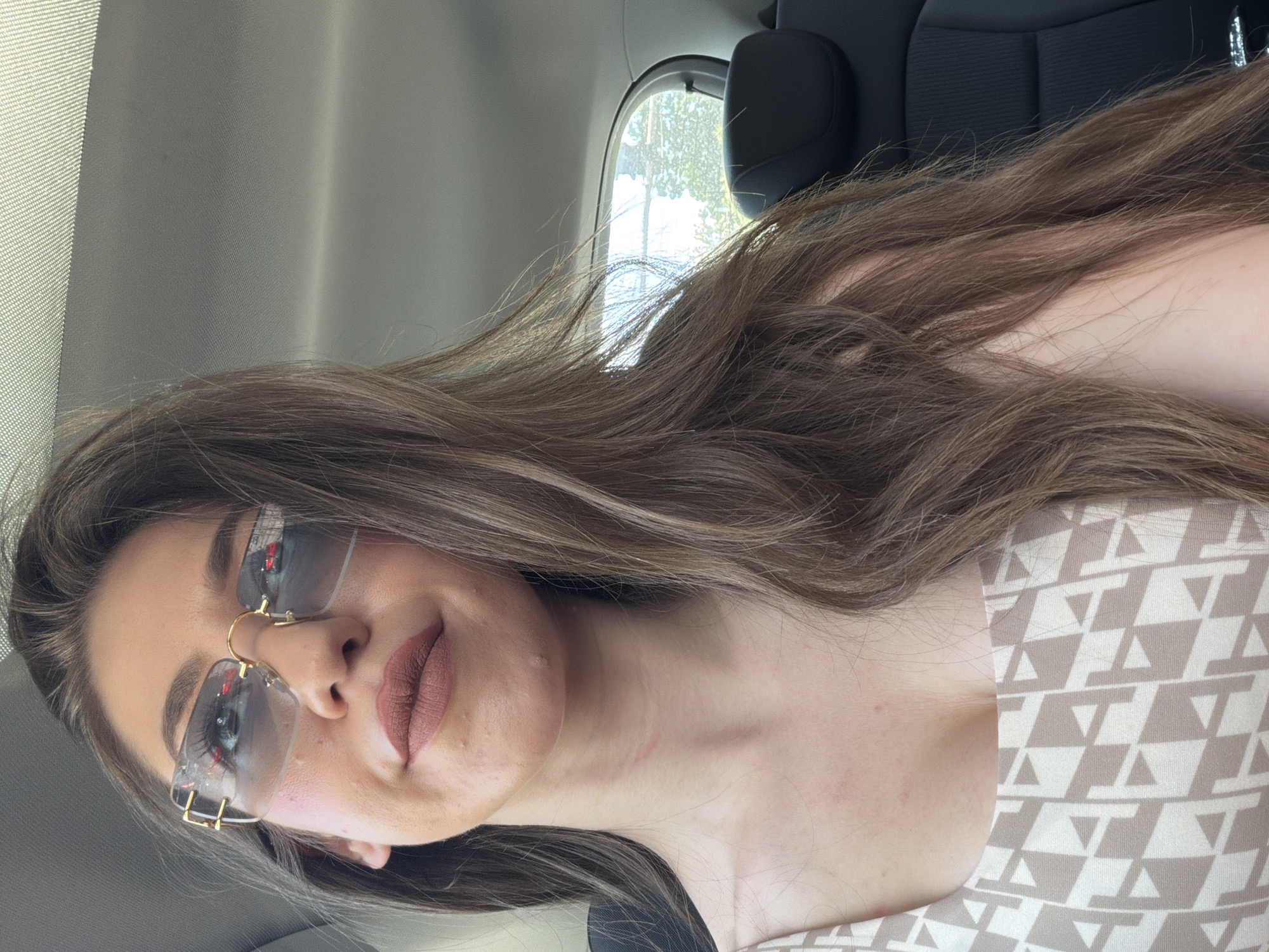 Woman takes car selfies in Sofia wearing sunglasses