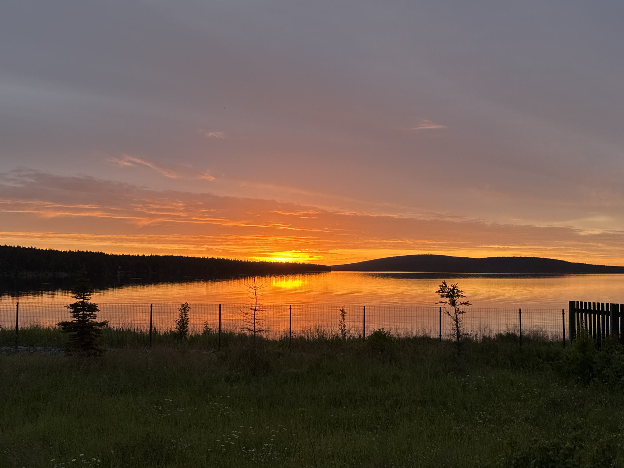 Vivid sunset over a calm lake, shoreline in view