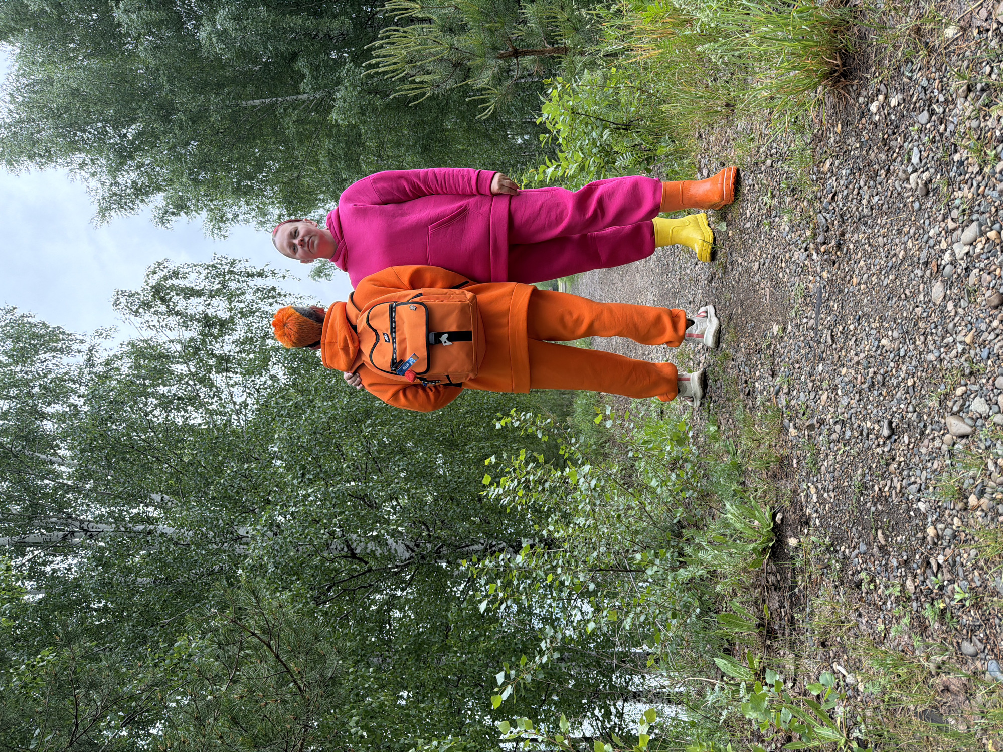 Two people in bright clothing spotted on wooded path