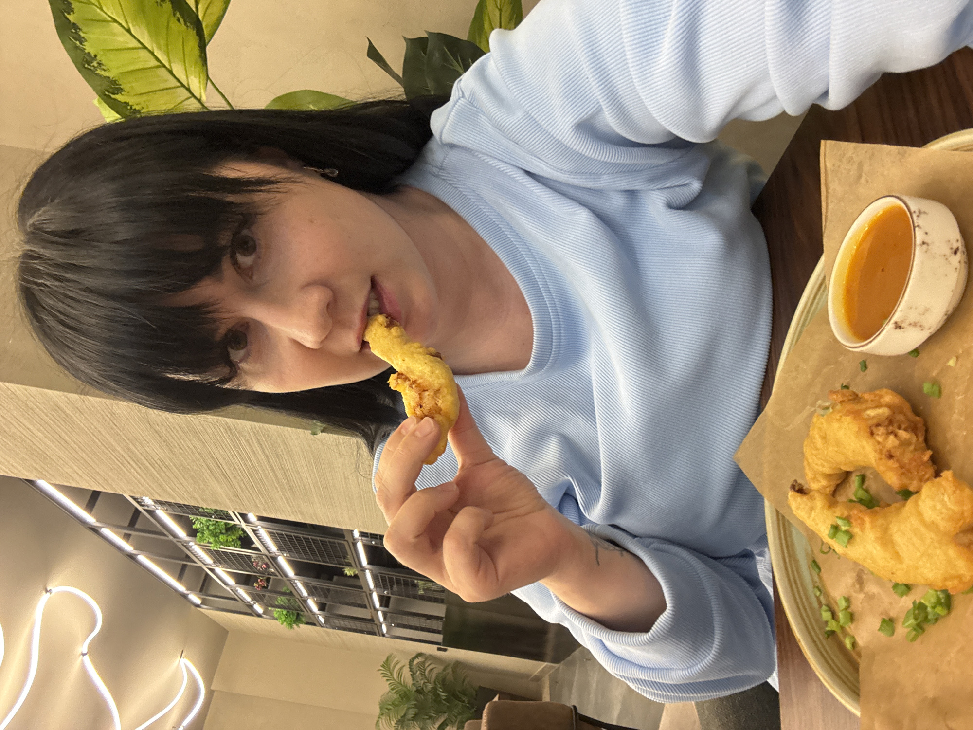 Woman enjoys fried food at table in Izhevsk