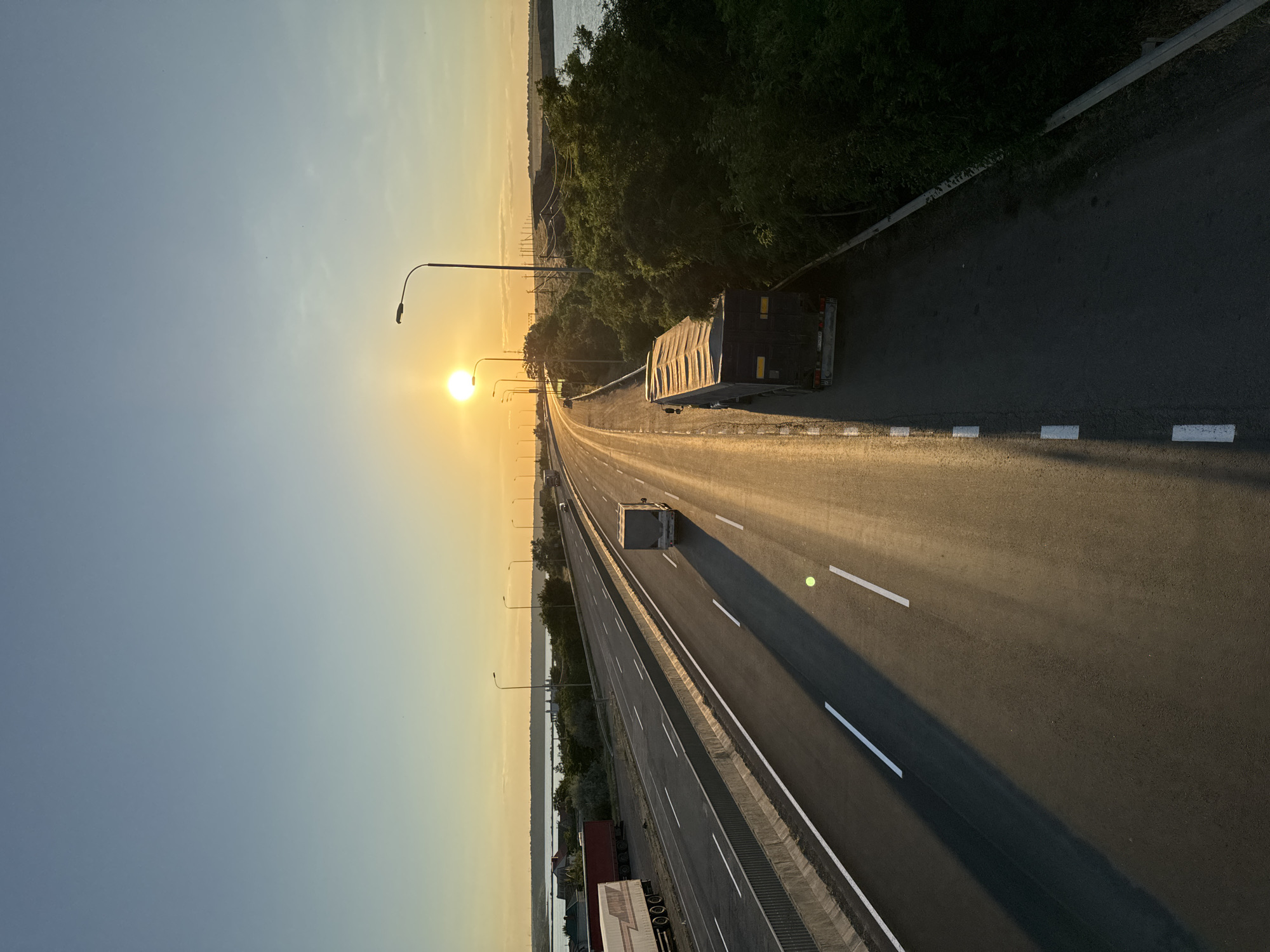 Highway traffic beside a river at golden hour, southern Ukraine