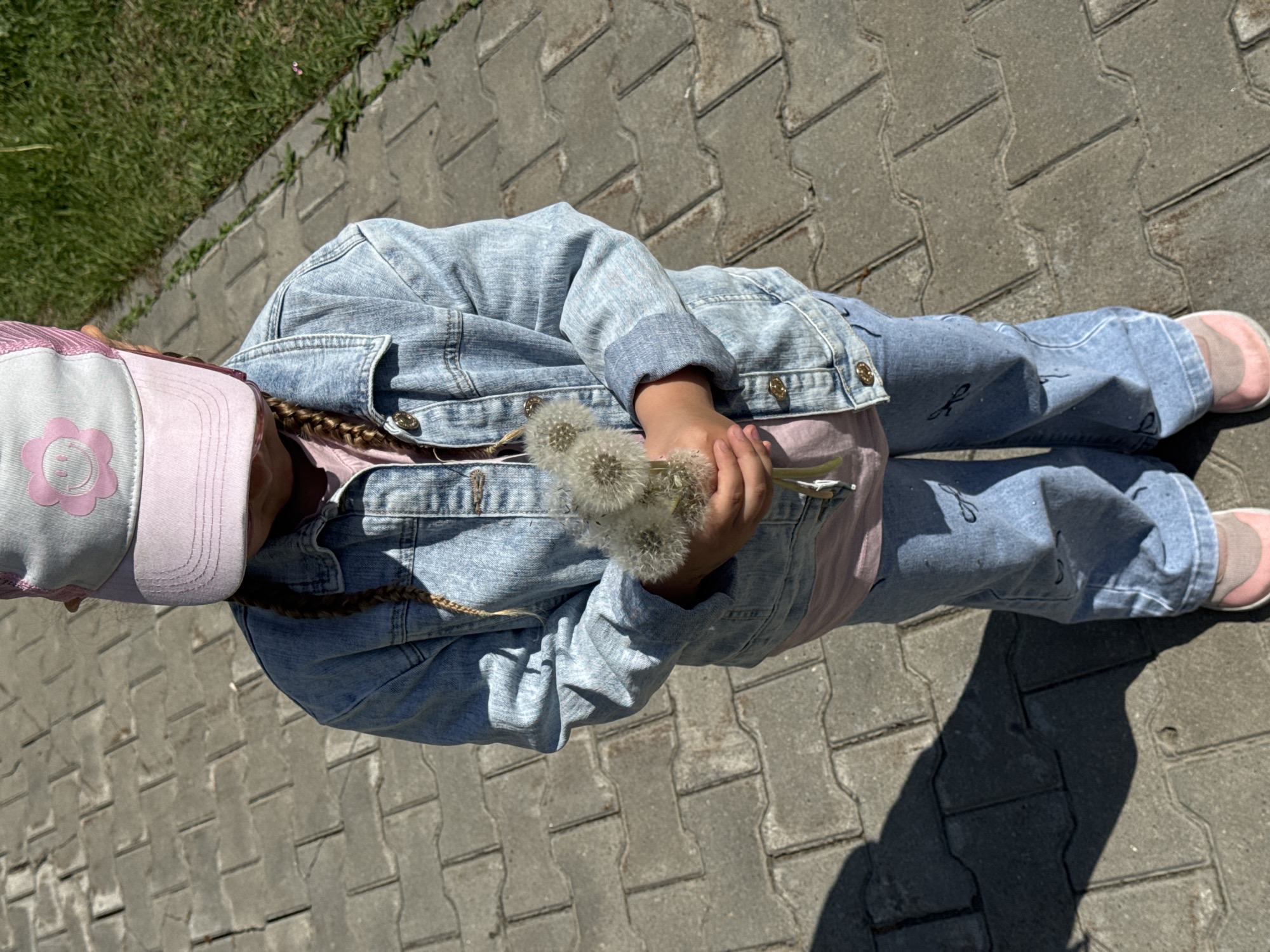 Child collects dandelion bouquet on sunny morning in Megion