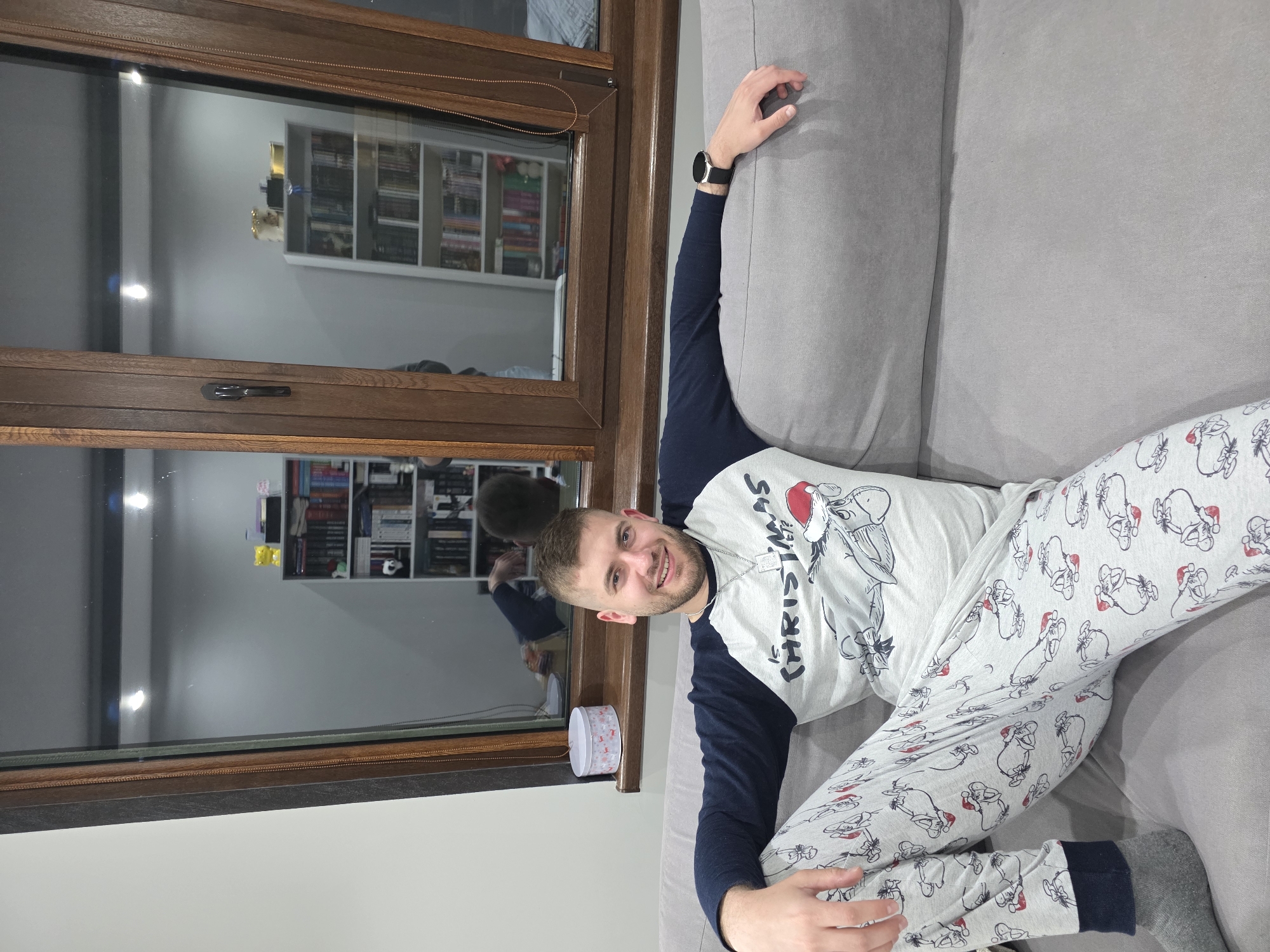 Man in Christmas pajamas holds pineapple at Bulgarian home