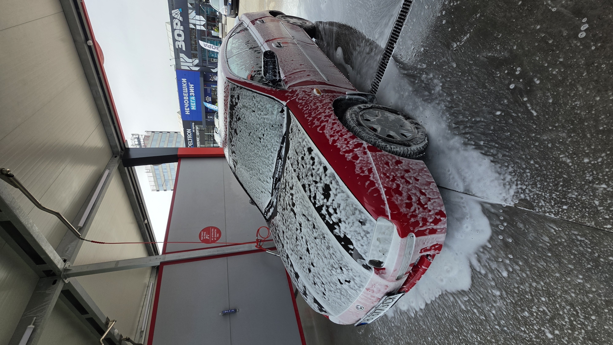 Red car being washed at self-service facility in Varna