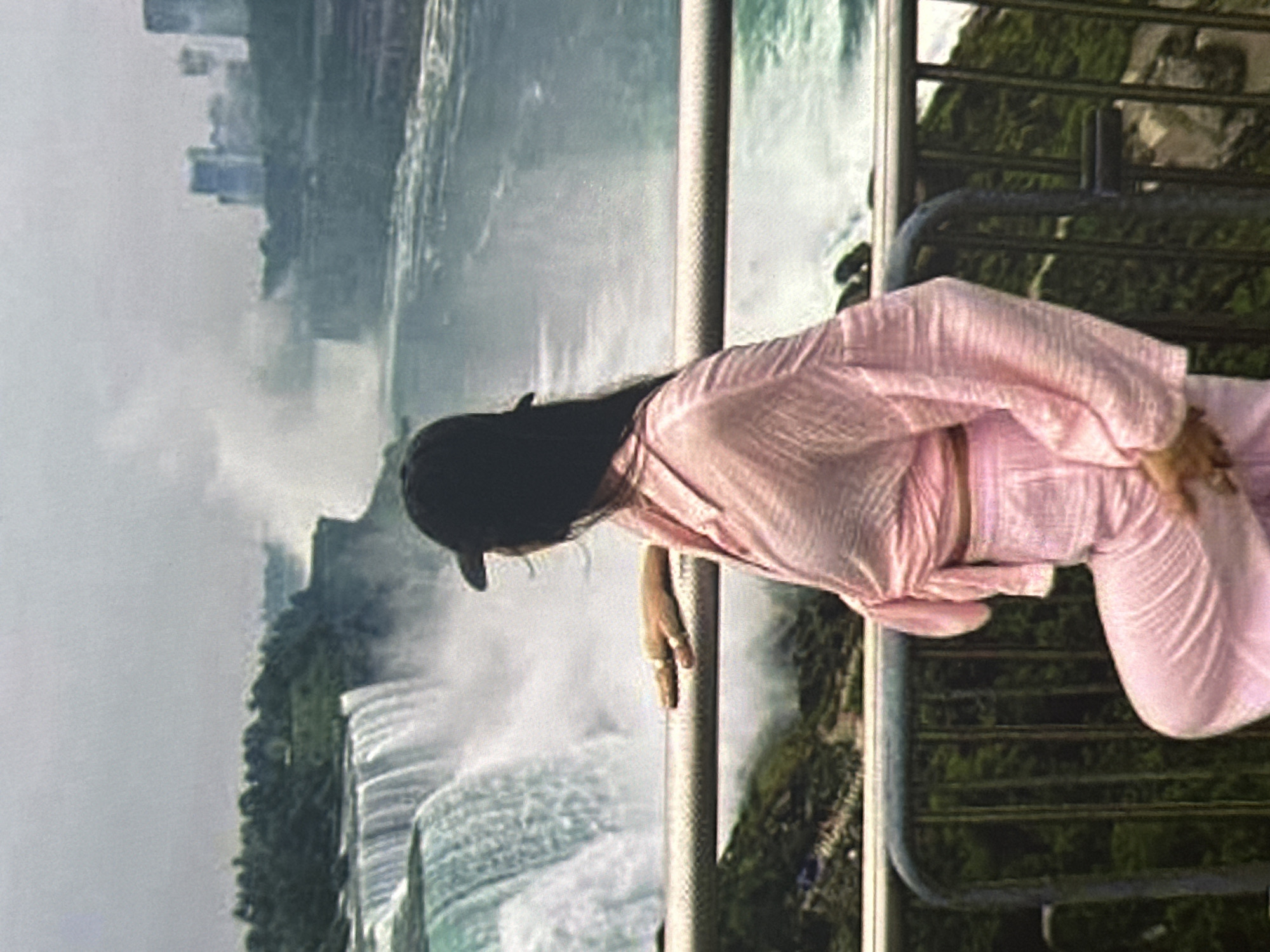 Tourist views waterfall from railing in Krasnoyarsk, Russia