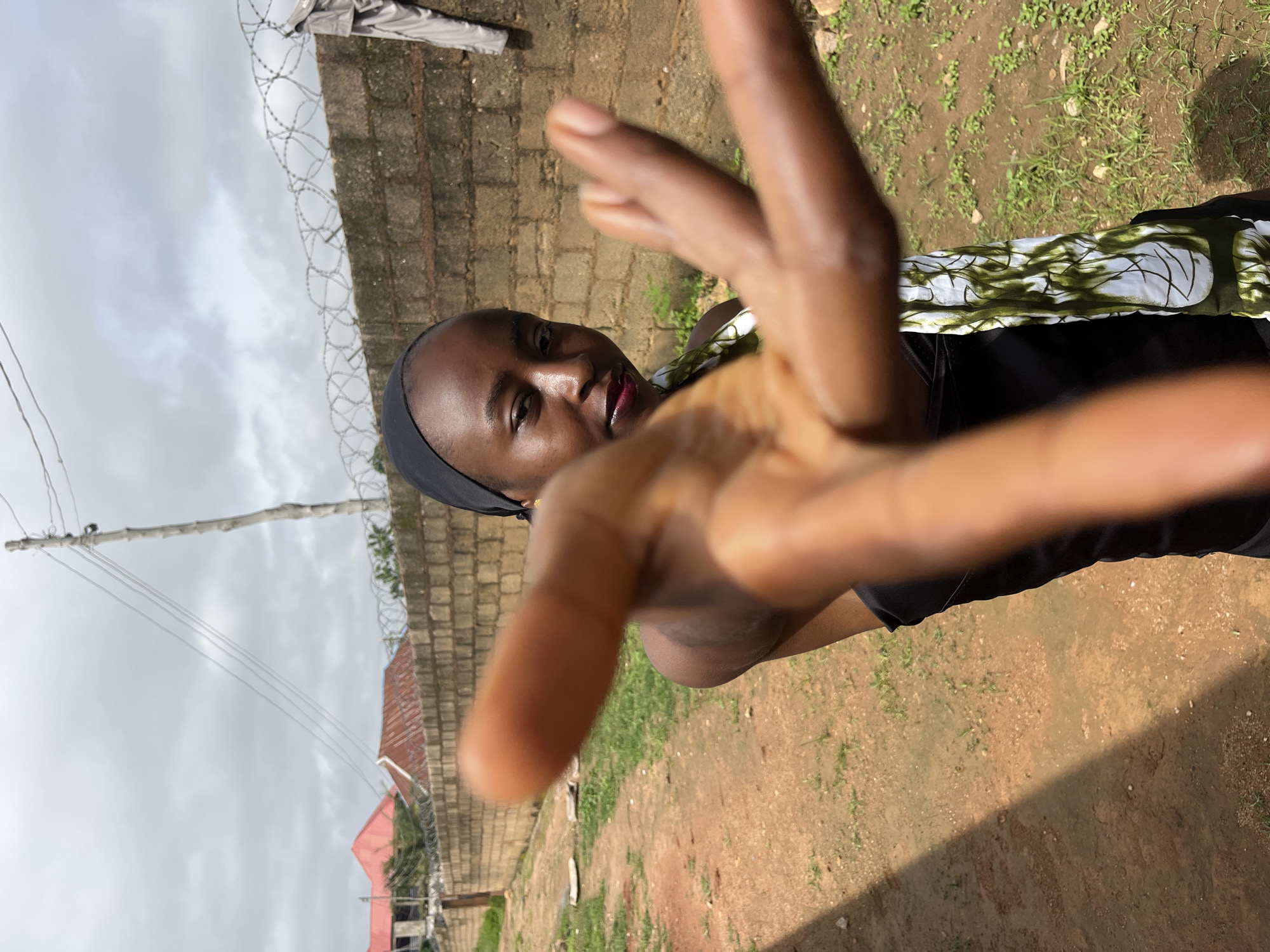 Outdoor portrait session against a brick wall in Bukuru