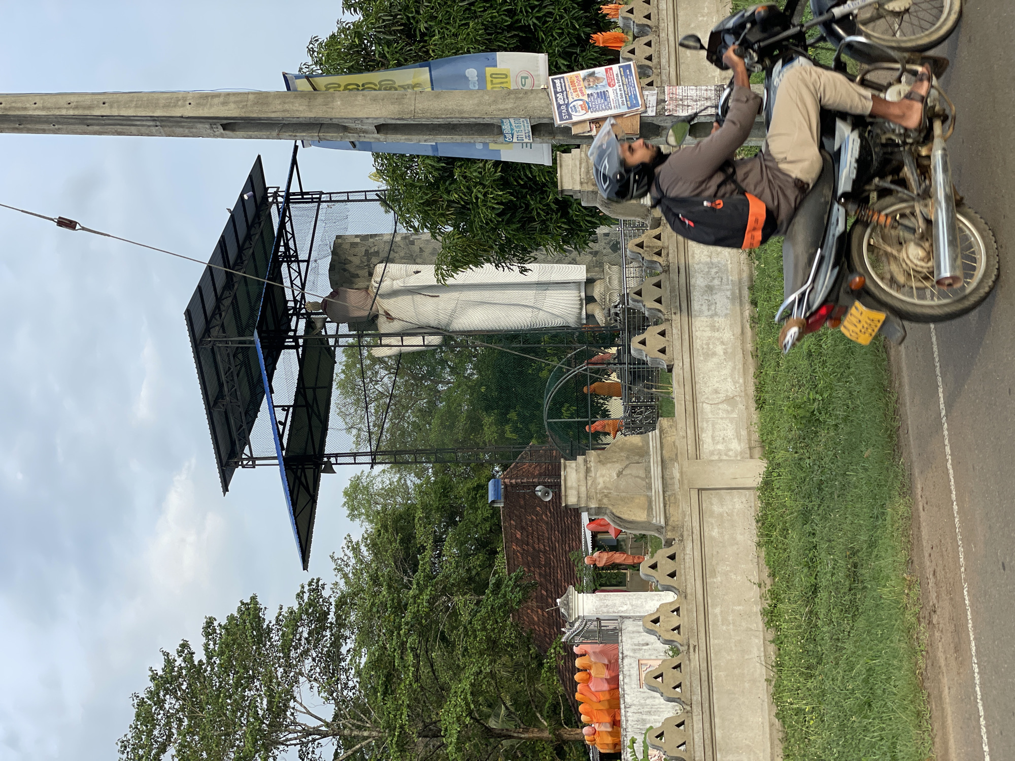 Buddha statue construction continues amid traditional Sri Lankan landscape