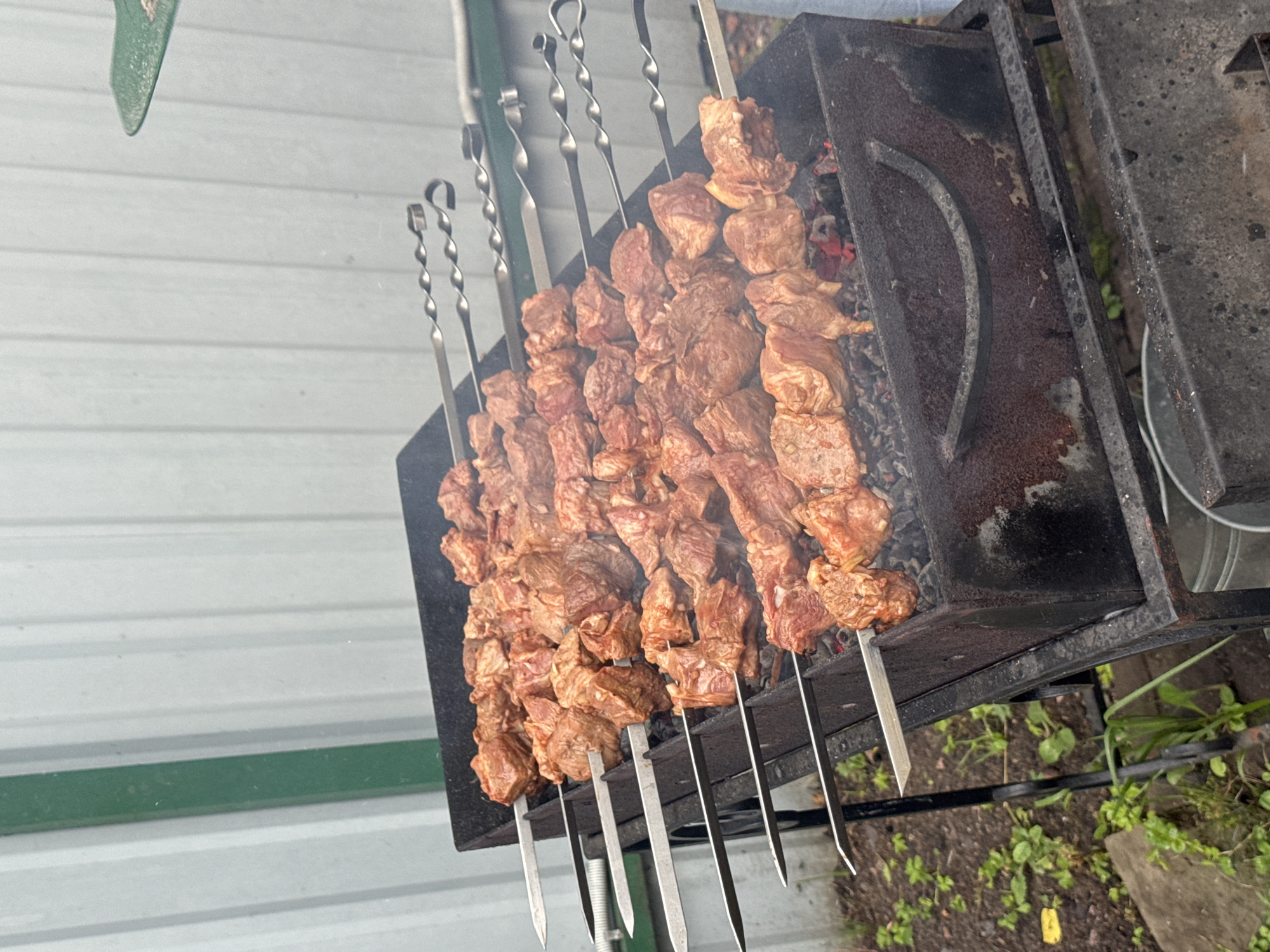 Charcoal grill loaded with skewers and sausages, suburban Moscow
