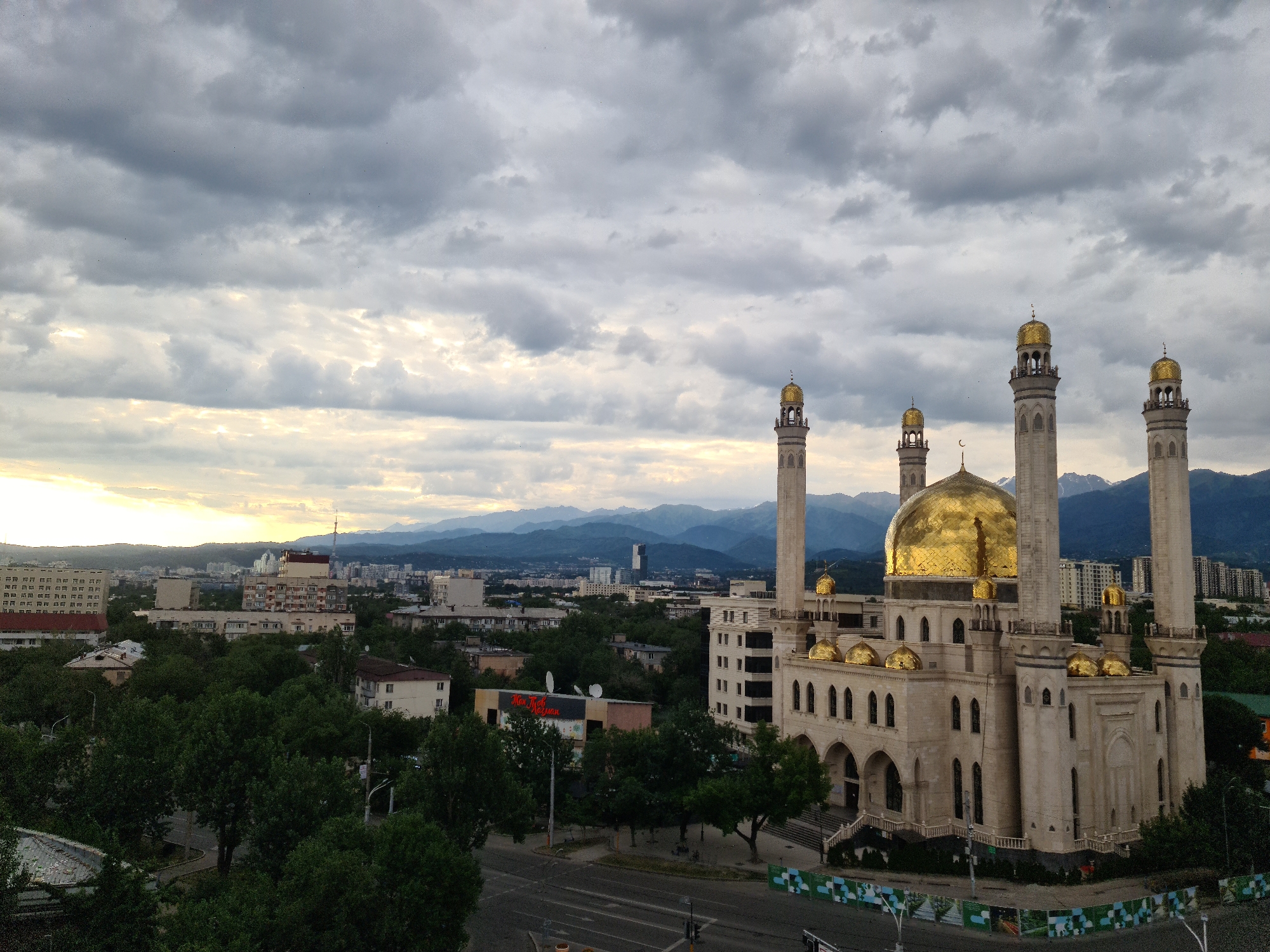 Almaty's Central Mosque and skyline under stormy skies