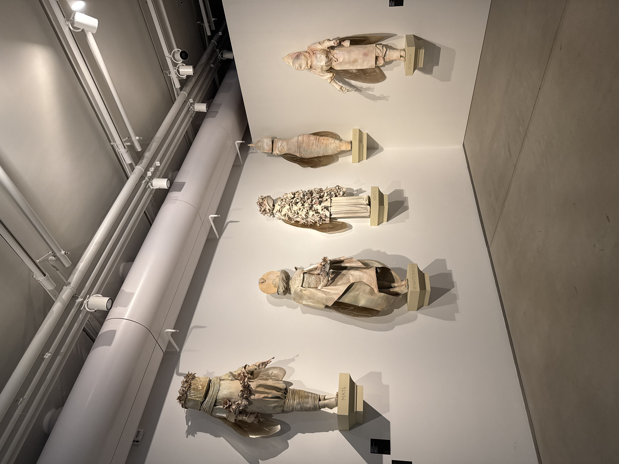 Art exhibition displays doll figures and multi-panel painting in Moscow