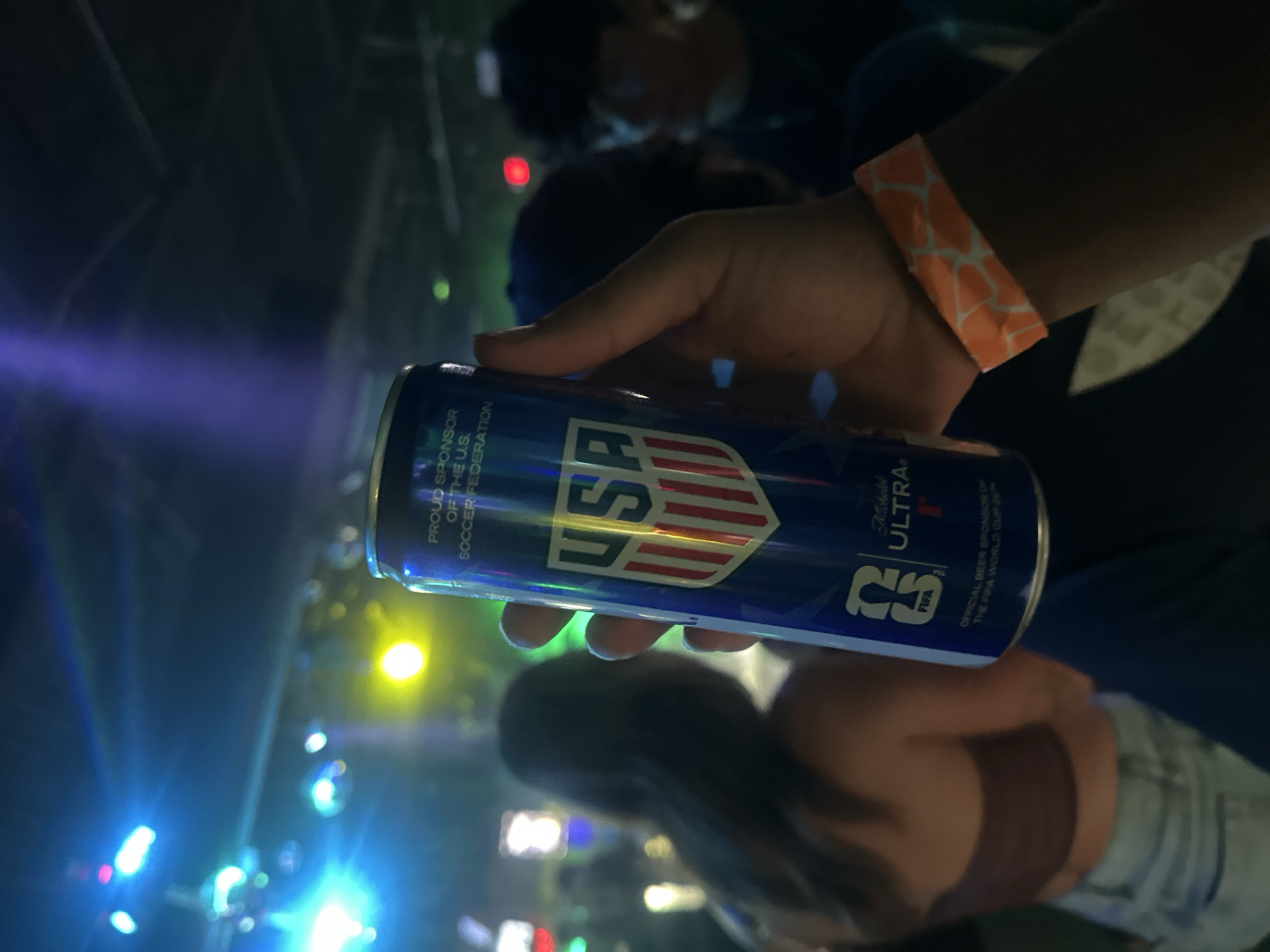 Person holds USA-branded blue can at Tampa indoor event