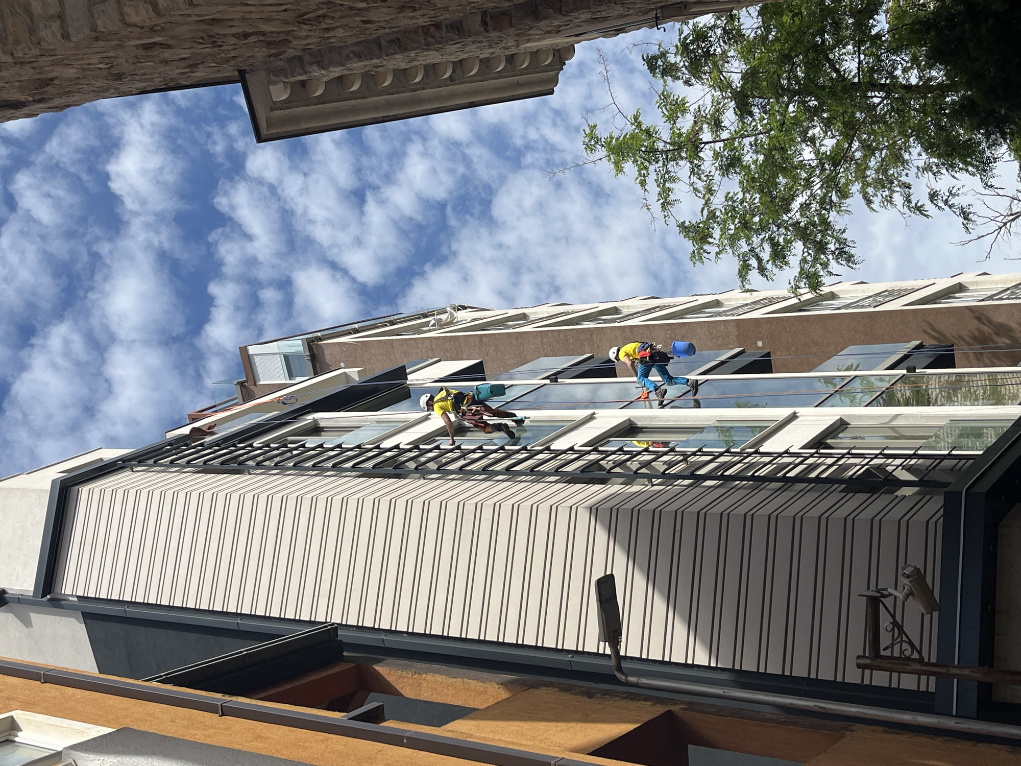 Window washers clean modern building in Budva Montenegro