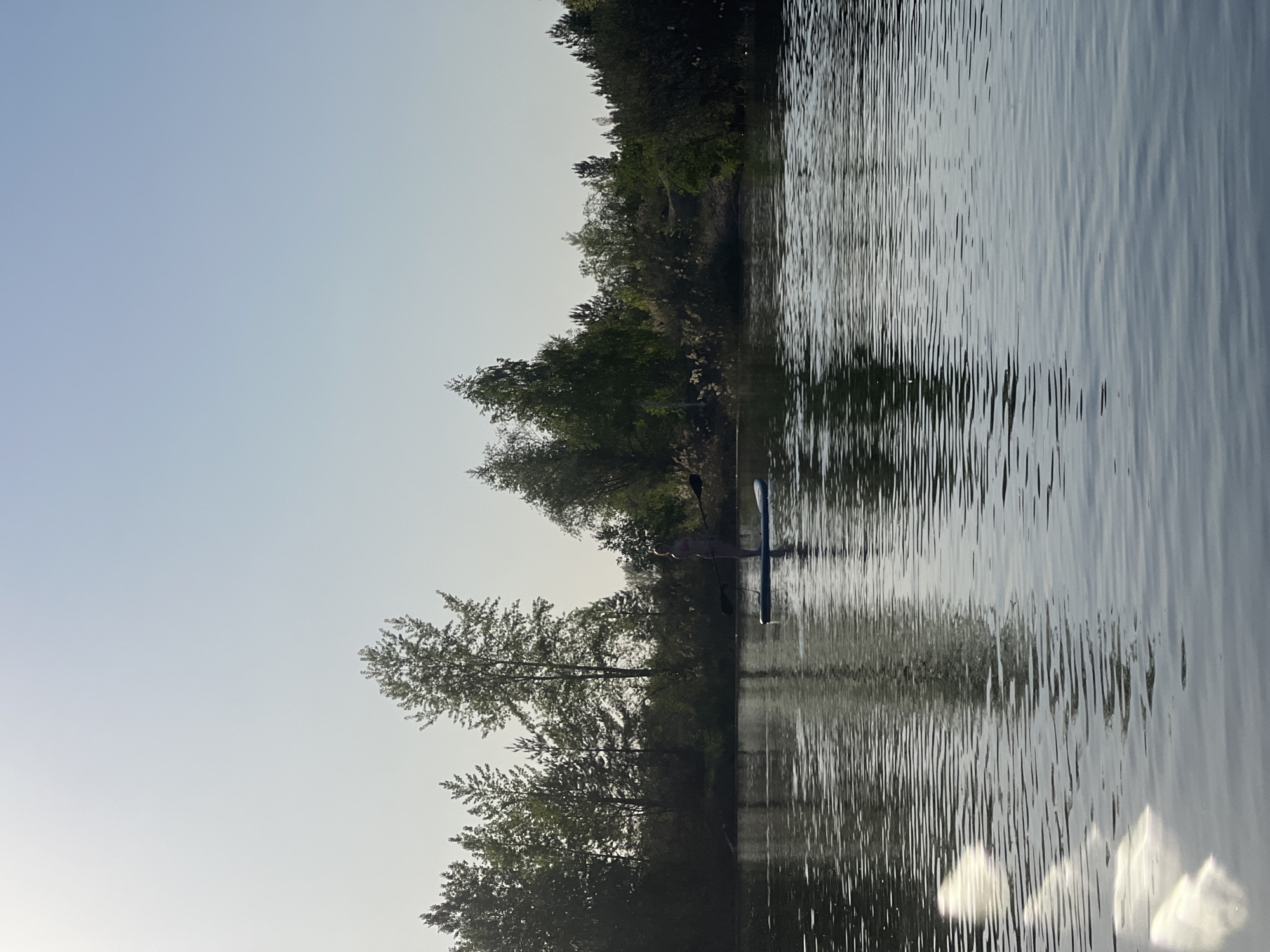 Paddleboarder enjoys sunny afternoon on lake near Novyi, Russia