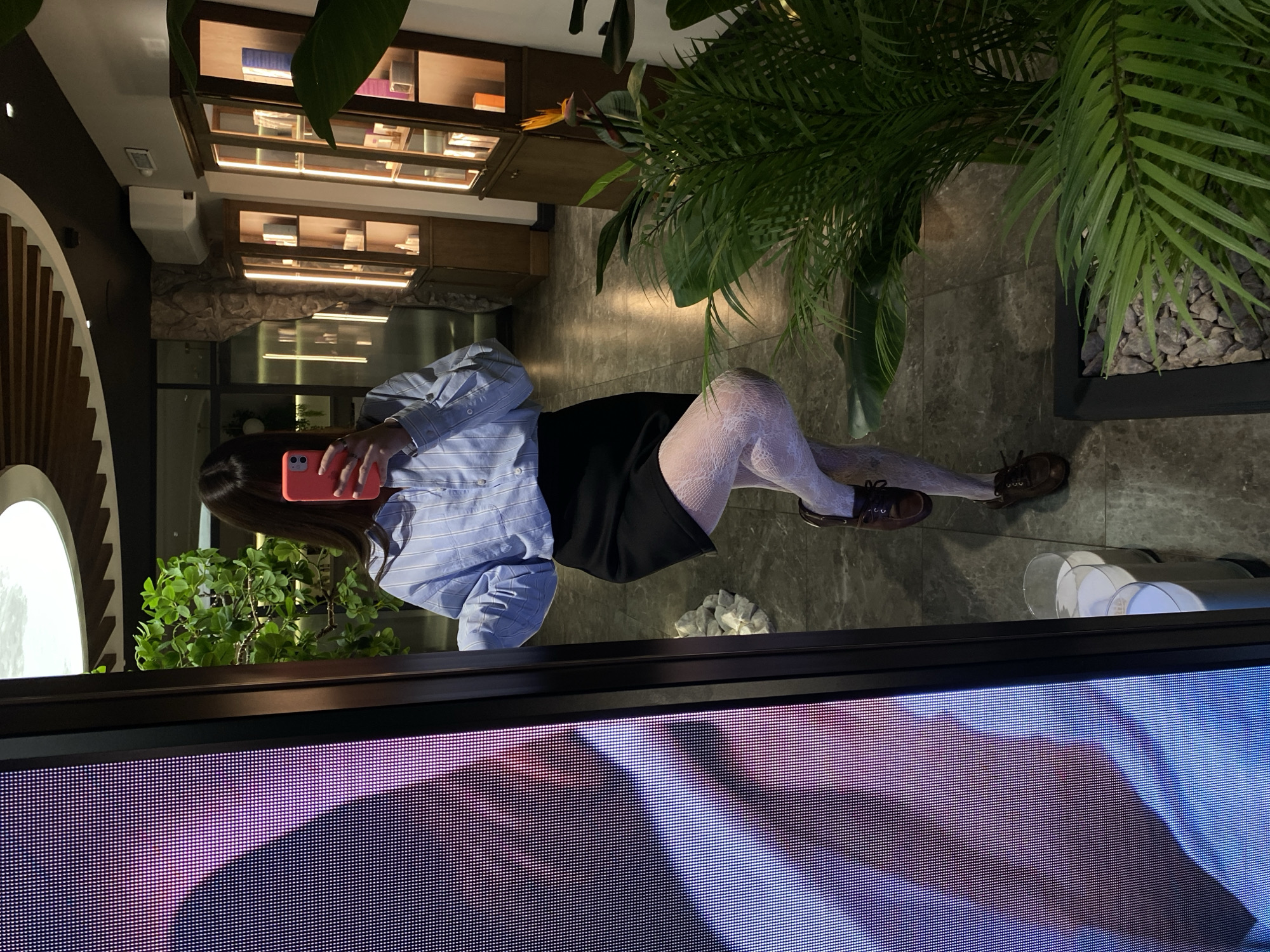 Woman takes selfies with pink phone in Votkinsk mirror