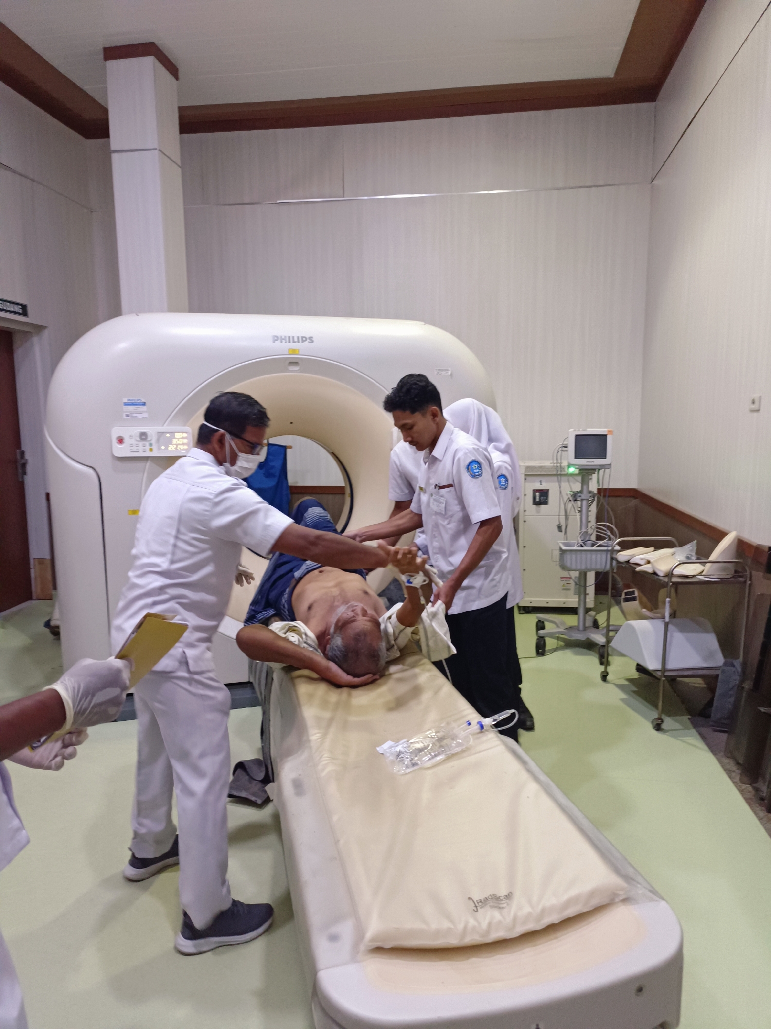 CT scan procedure underway with multiple medical staff attending